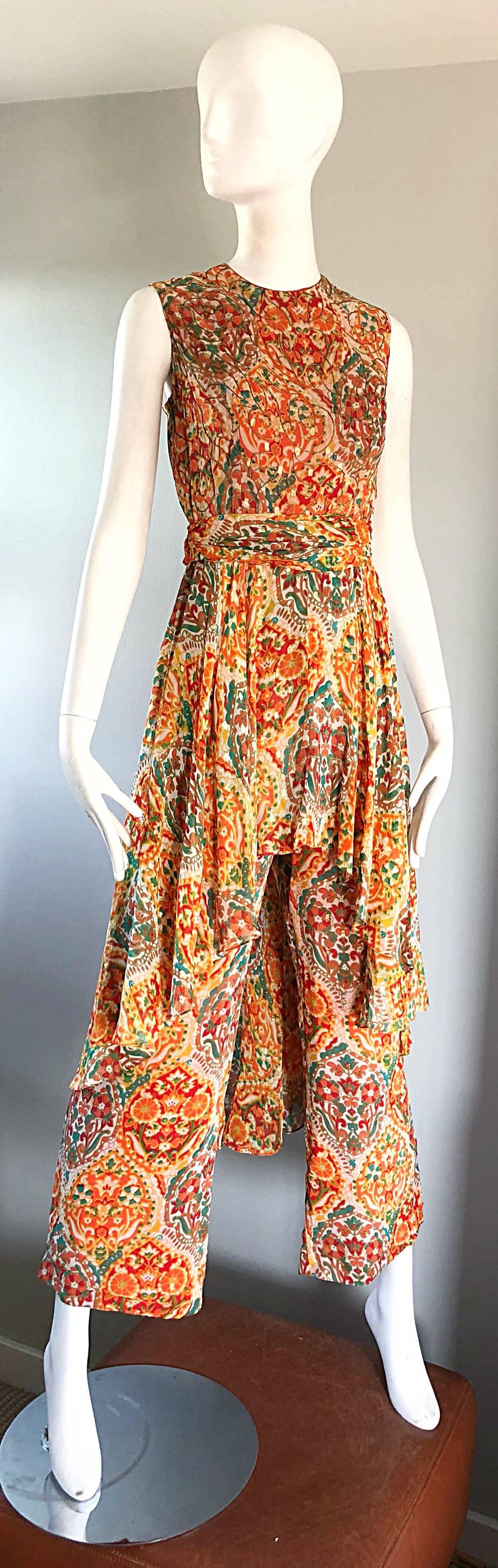 Amazing 70s OSCAR DE LA RENTA silk wide leg boho batik print jumpsuit, with attached skirt! Features vibrant colors of orange, green, brown, burgundy, yellow throughout. Fitted bodice features gold silk threading throughout. Wide palazzo legs. Full
