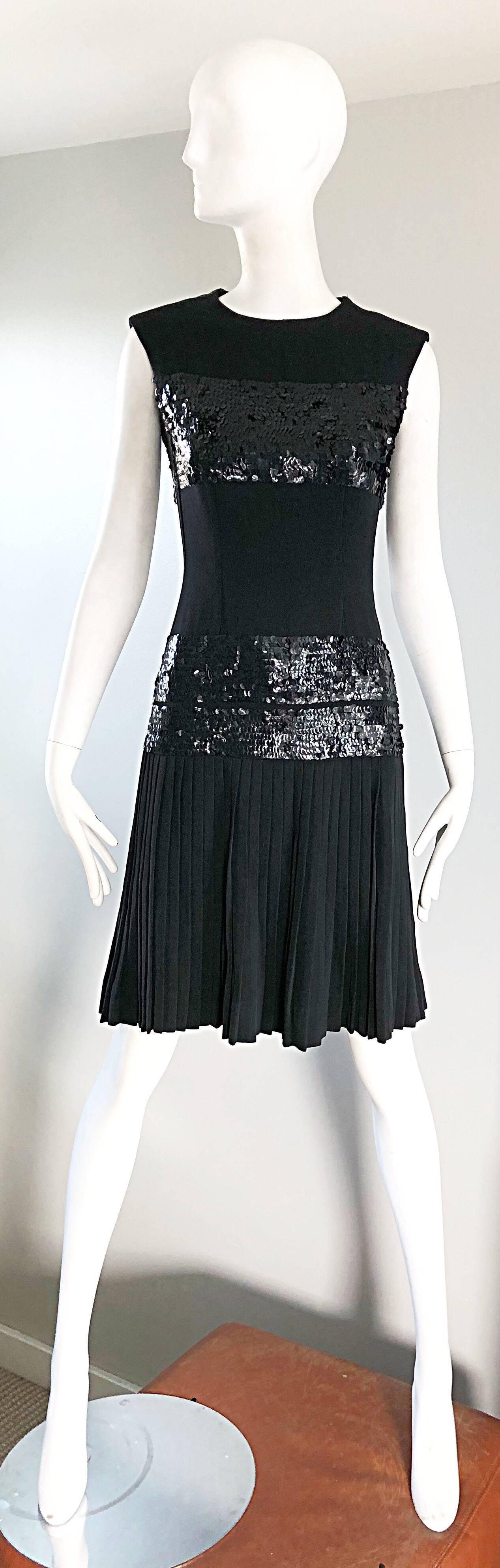 Beautiful chic black crepe 1960s sequined shift dres! Features hundreds of black sequins on the bodice and waist. Fitted bodice, with an accordion skirt that looks fantastic on! Full metal zipper up the back with hook-and-eye closure. The perfect