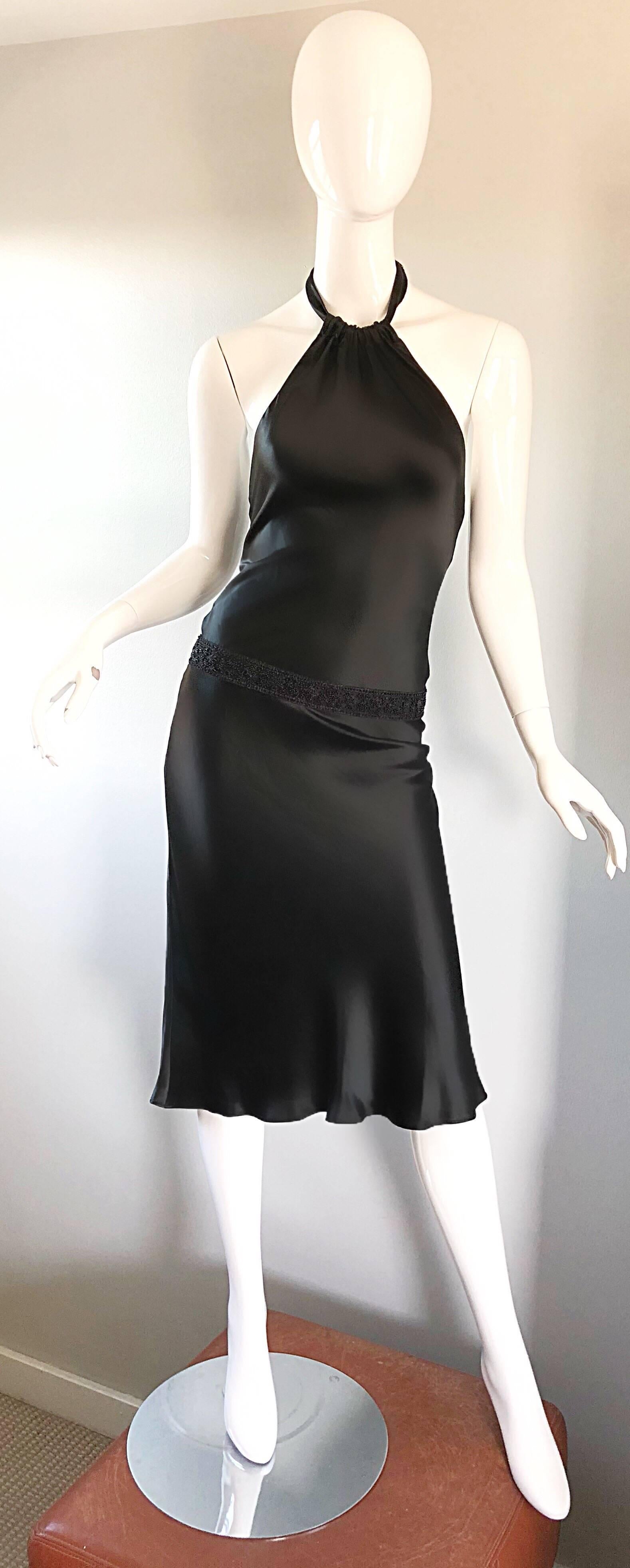 Striking 1990s VERA WANG black slinky beaded halter dress! Features a lovely silhouette that flatters an array of body shapes. Slightly dropped beaded waist gives an ode to the 20s. Hidden zipper up the side with hook-and-eye closure. Halter ties at