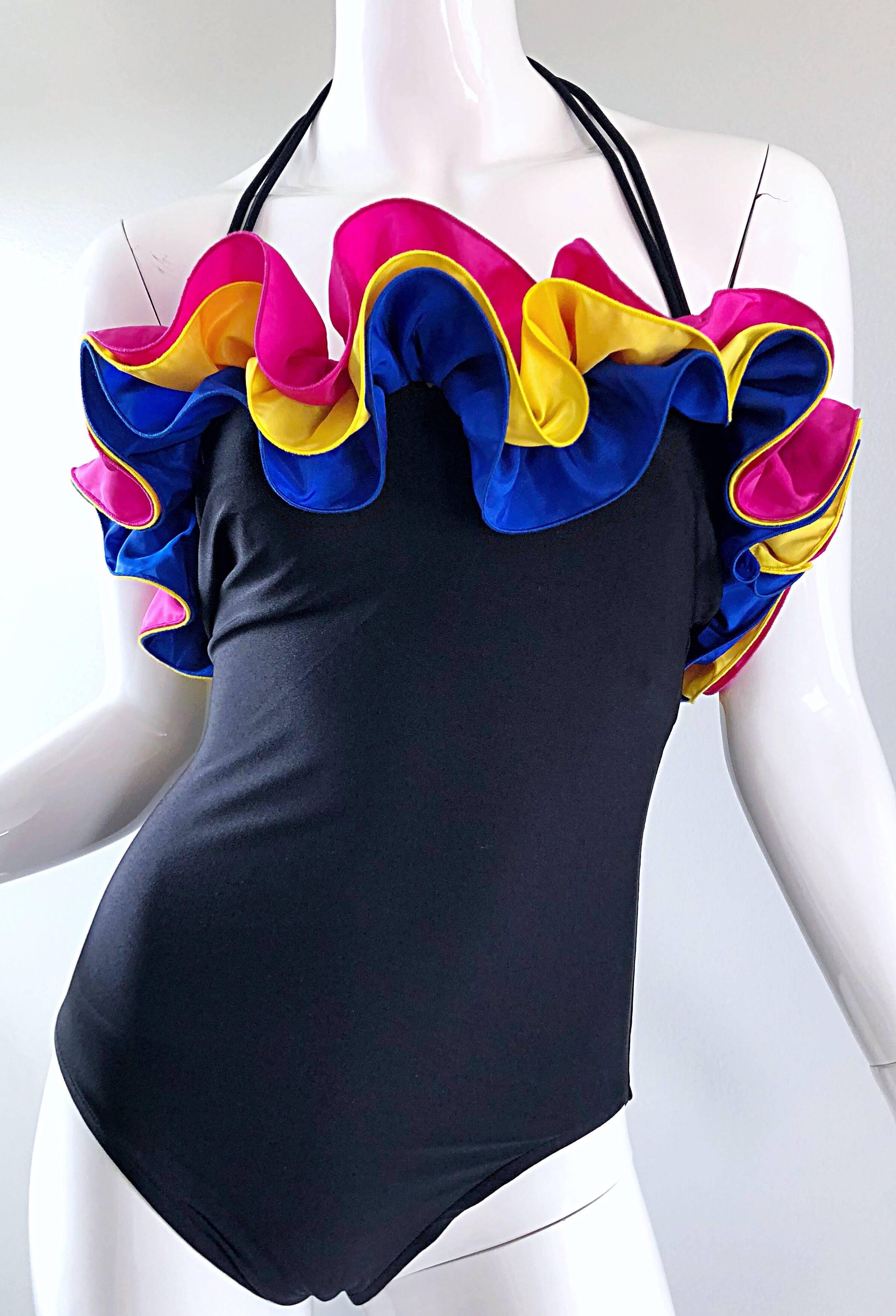Amazing new with tags vintage BILL BLASS flamenco style one piece swimsuit or bodysuit, with detachable halter strap! Features three layers of ruffles around the top. Vibrant colors of blue, yellow and hot pink, with a black body. Comes with