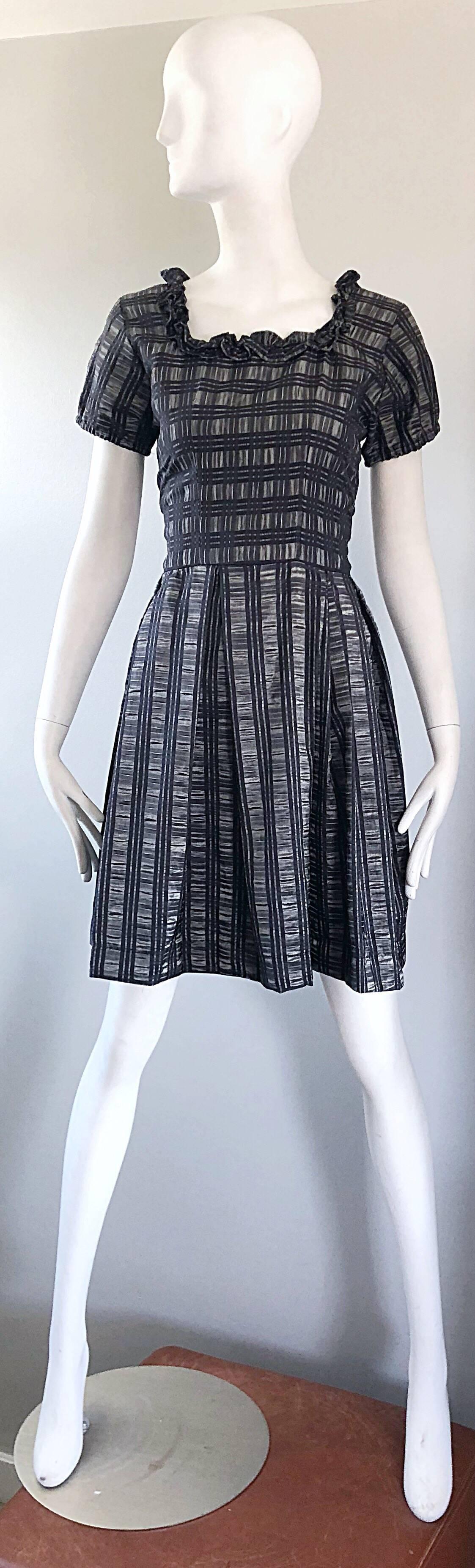 Pretty 1950s silk taffeta short puff sleeve dress! Features a grey metallic backdrop with black plaid printed throughout. Fitted tailored bodice with ruffles along the neckline. Chic puff sleeves feature elastic cuffs. Full forgiving skirt can also