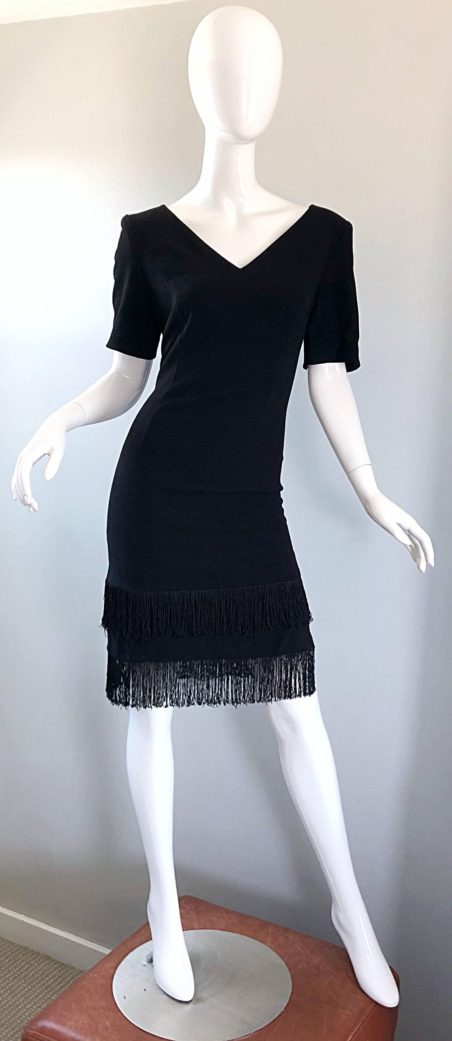 Amazing early 90s does 20s ESCADA by MARGARETHA LEY black flapper inspired virgin wool fringe dress! Features a tailored bodice with a v-neck and short sleeves. Two tiers of black fringe across the bottom hem. Hidden zipper up the back with