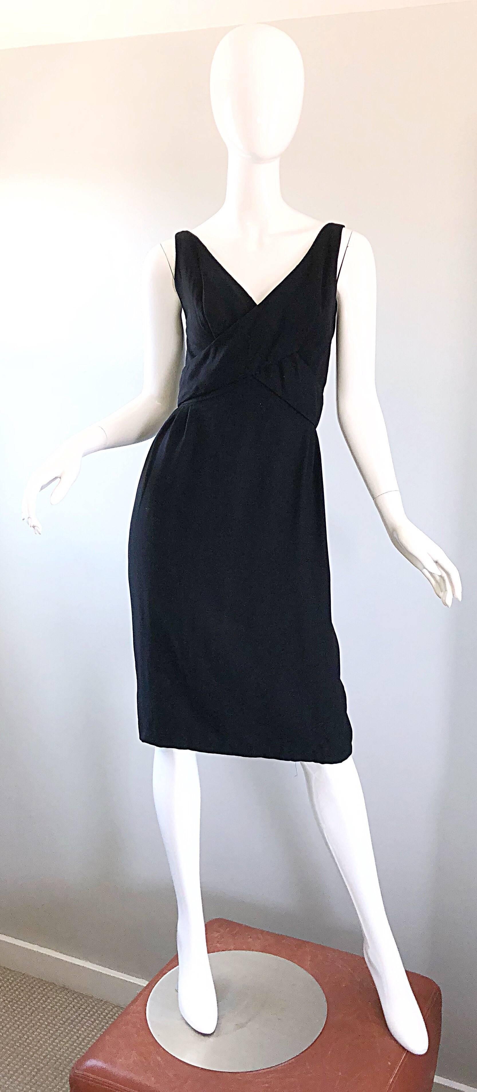 Perfect late 1950s black crepe sleeveless dress! The perfect LBD that is an essential timeless addition to any wardrobe. Features soft black crepe, with a wrap around strap that buttons shut with three fabric covered buttons at center back. Full