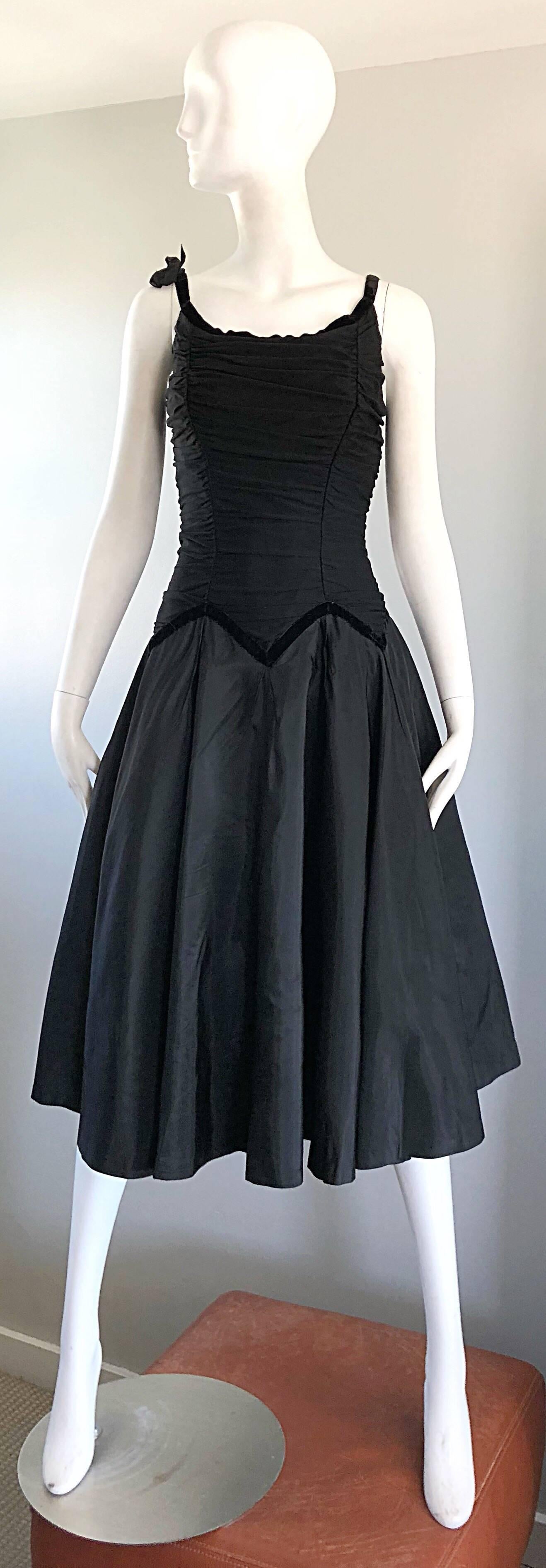 Beautiful 1950s black silk taffeta fit n' flare cocktail dress! Features a ruched silk mesh bodice with flattering black velvet zig zag accents along the waist. Black velvet trip along the neck and sleeves, with a chic little bow on the right