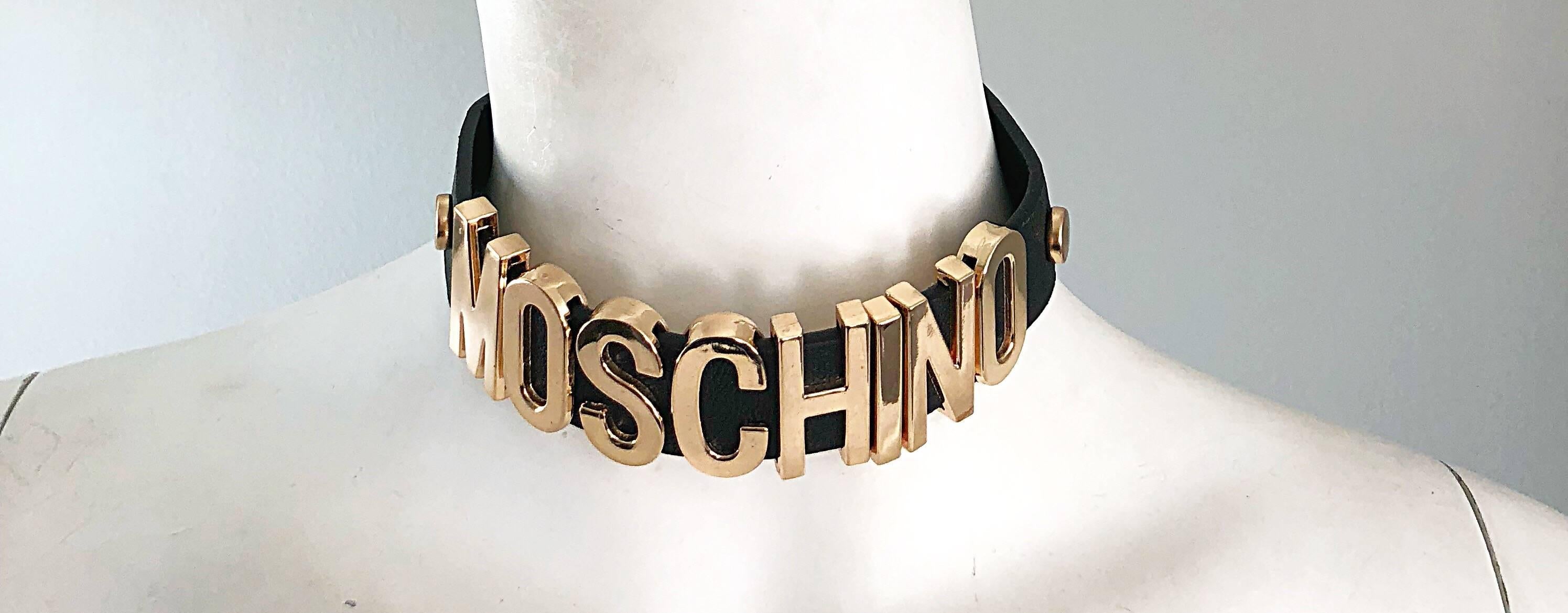 Amazing late 90s MOSCHINO black leather and gold logo mania choker necklace! Features gold metal letters that spell out Moschino with gold metal studs at each side. Two hidden adjustable snaps on the back. 
Can easily be dressed up or down. Great