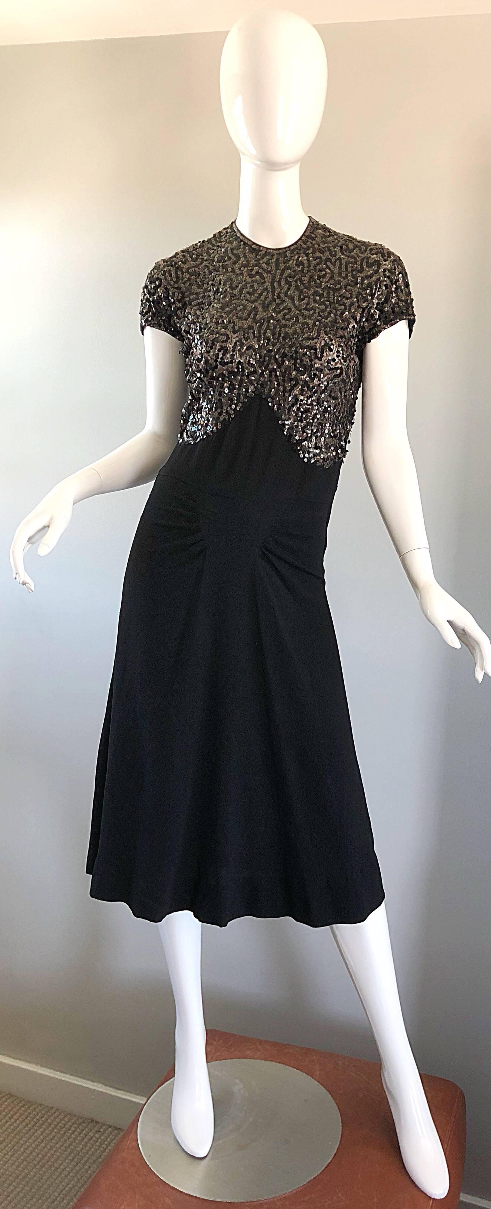 Beautiful 1940s black crepe sequined cocktail dress! Features hundreds of hand-sewn black sequins on the entire front bodice. Free flowy skirt is both flattering and comfortable. Metal zipper up the side. Intricate slimming pleated detail at the