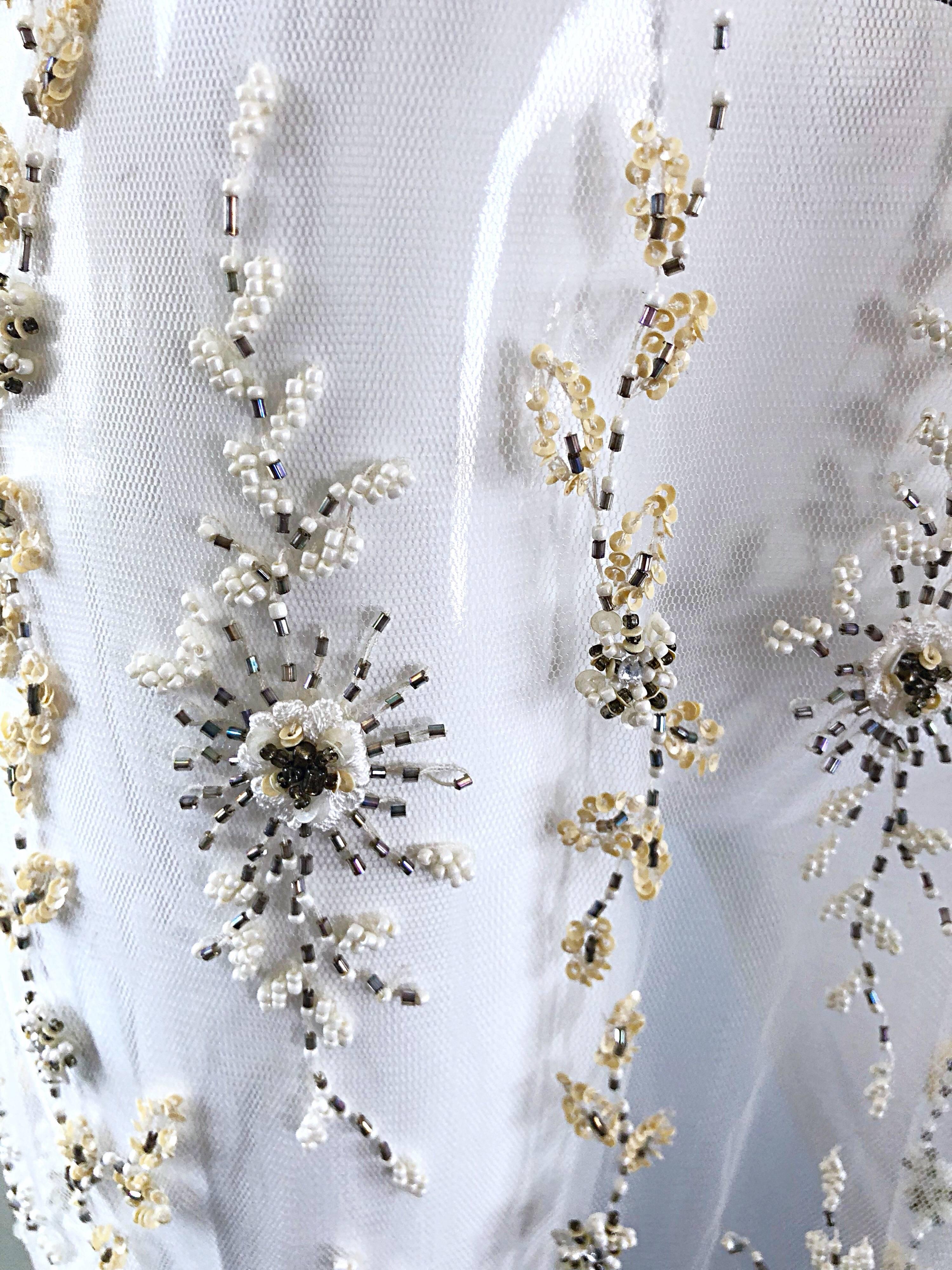 Magnifique châle / foulard vintage blanc transparent surdimensionné pour piano ! Présente des milliers de perles, perles, strass et paillettes cousus à la main. Les pompons en perles sont dotés de paillassons iridescents roses aux extrémités. Il