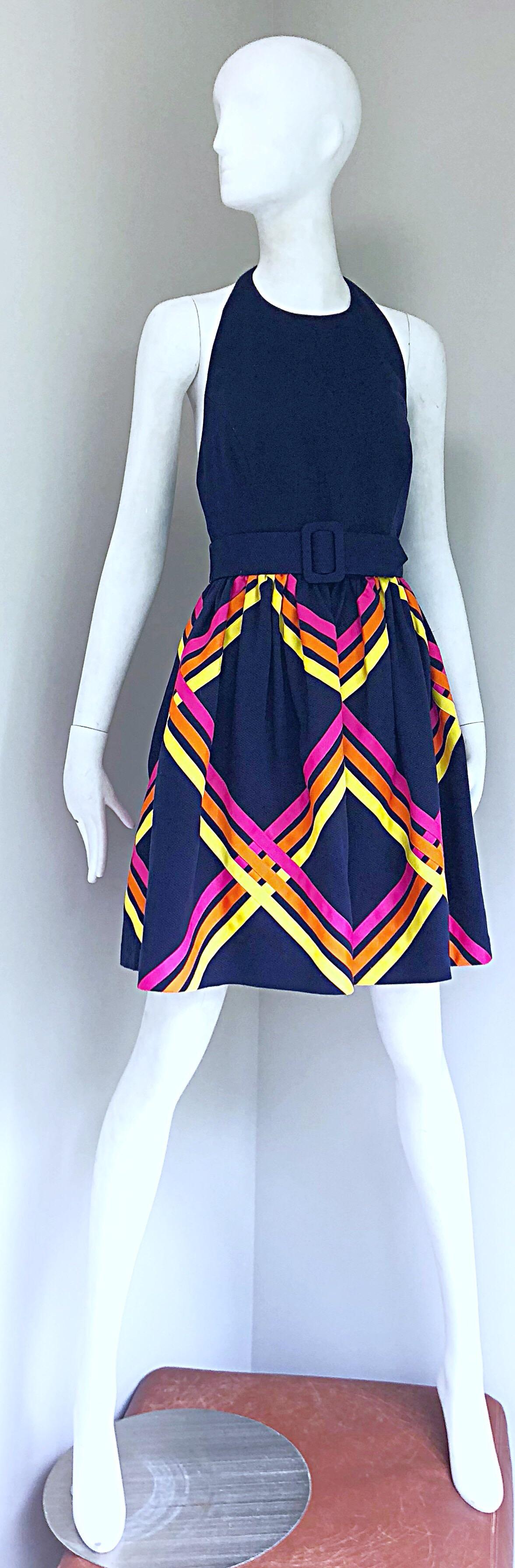 Chic new with tags deadstock BILL BLASS navy blue belted 
A-Line cotton pique halter dress! Features a fitted bodice, with a full forgiving and flattering A-Line skirt. Hot pink, orange and yellow grosgrain ribbon detail on the front and back of the