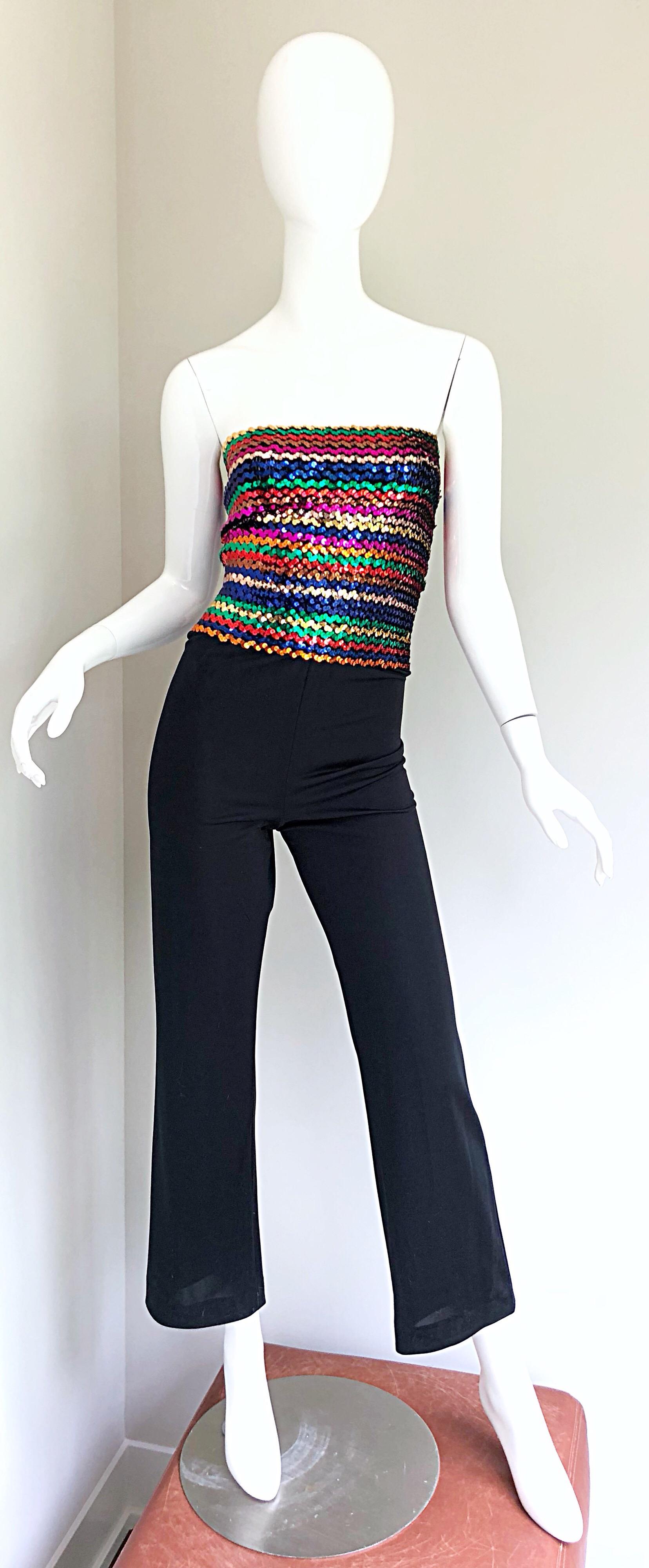 Amazing and sexy 1970s strapless rainbow sequined jumpsuit! Features hundreds of hand-sewn sequins on a soft knit. Vibrant rainbow colors of hot pink, blue, gold, green, purple, red, orange and bronze sequins. Solid black slightly flared jersey