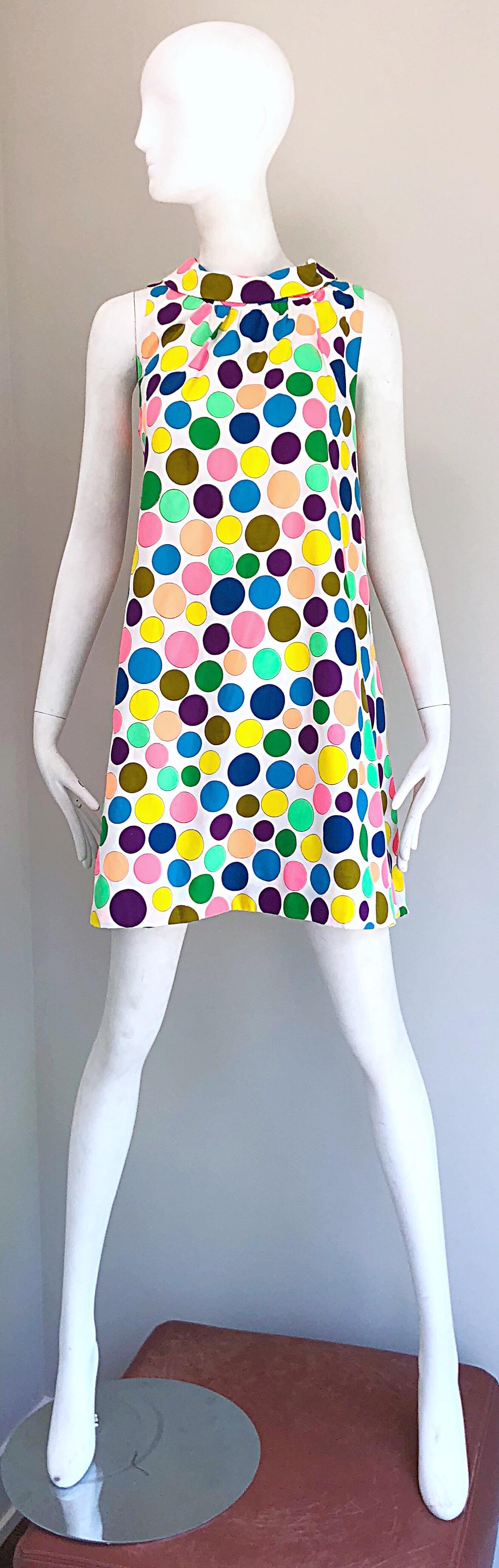 Chic mid 1960s cotton trapeze A-Line cotton dress! Features a mock neck with a flattering trapeze fit! hire background with vibrant colored polka dots throughout the entire dress. Purple, blue, green, yellow, turquoise definitely matches an array of