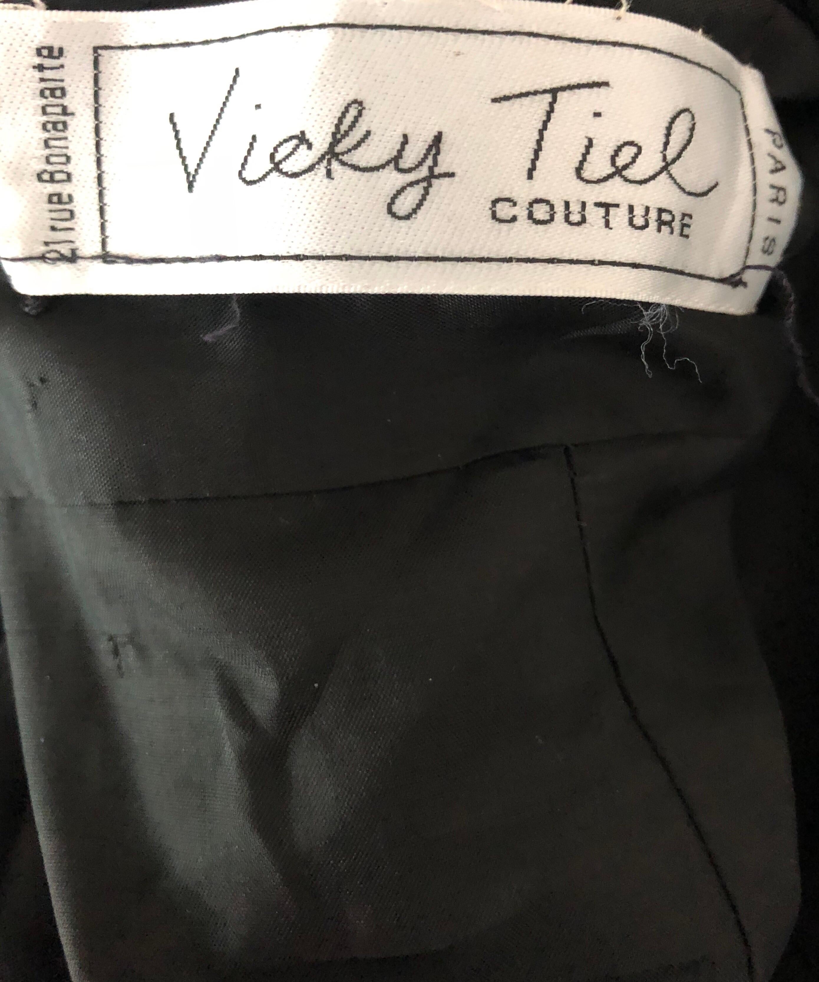 Gorgeous vintage late 80s VICKY TIEL COUTURE black silk jersey and lace cocktail dress! Features signature flattering gathers and drapes. Sweetheart bodice with a black French Lace above the bodice, sleeves, and at left hem. Rhinestones scattered