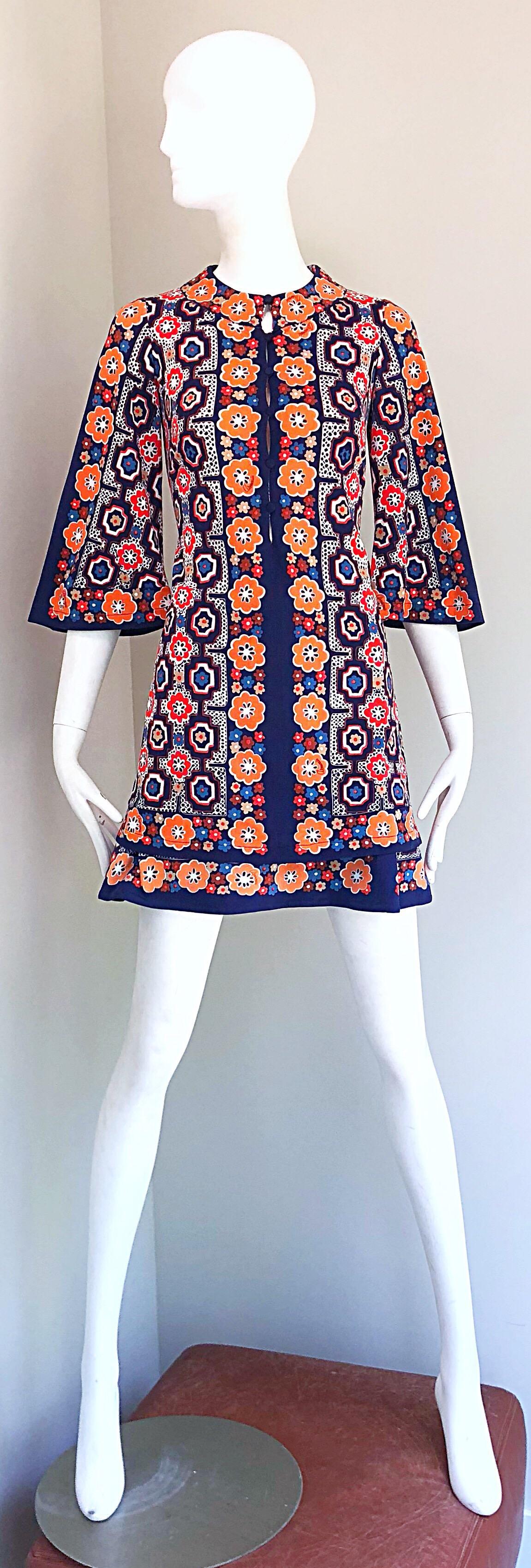 Chic 1960s ARMONIA Italian made jersey tunic and mini skirt ensemble! Features abstract and flower prints throughout in vibrant colors of orange, navy blue, tan, and light blue. Tunic buttons up the front and has dramatic bell sleeves. Mini A-line