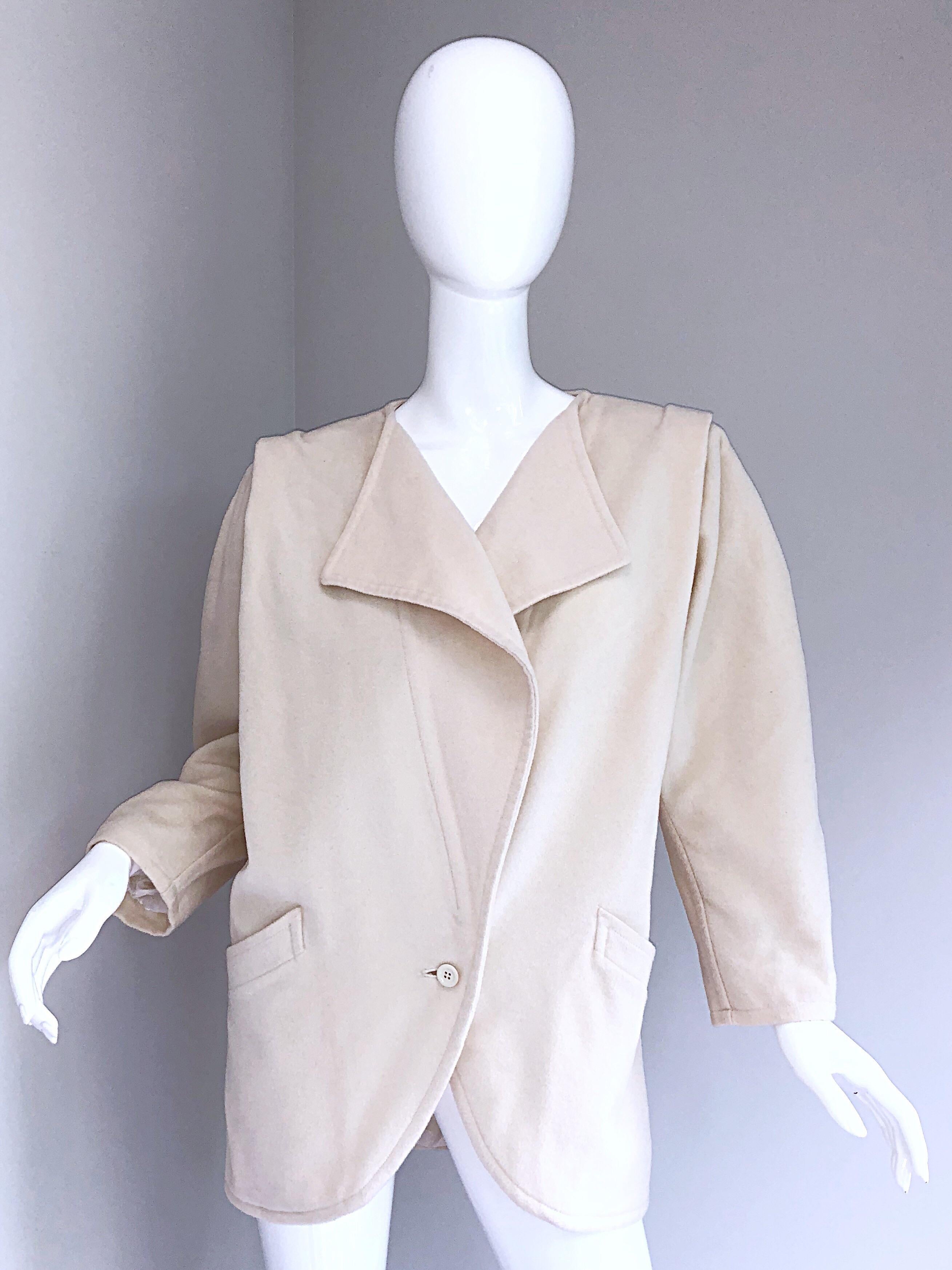 Favolosa e chic giacca vintage anni '80 di Emanuel Ungaro in lana vergine avorio / bianco sporco Avant Garde! Tanti dettagli con ancora più stile! Presenta una chiusura a un bottone e tasche su ciascun lato della vita. Spallacci incorporati e