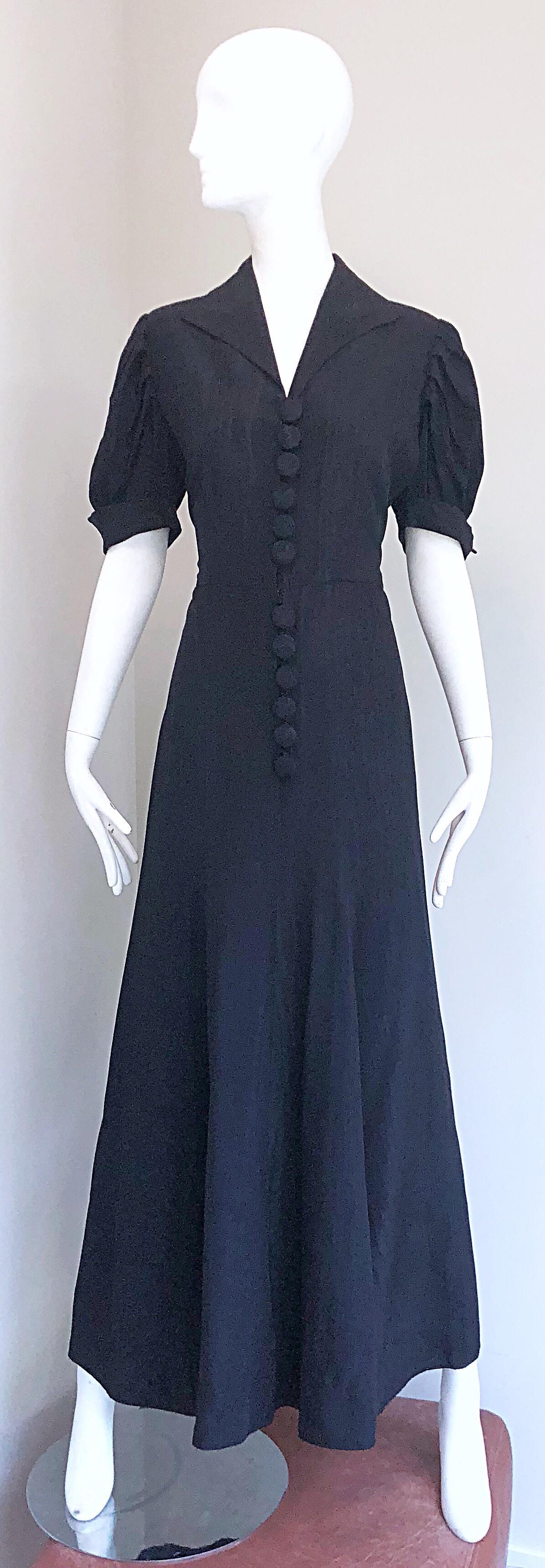 Gorgeous 1940s black silk moire Avant Garde evening gown! Features a luxurious silk moire that gives off just the right amount of sheen. Buttons up the front with the same silk moire fabric covering the buttons. Hidden hook-and-eye closure at inner