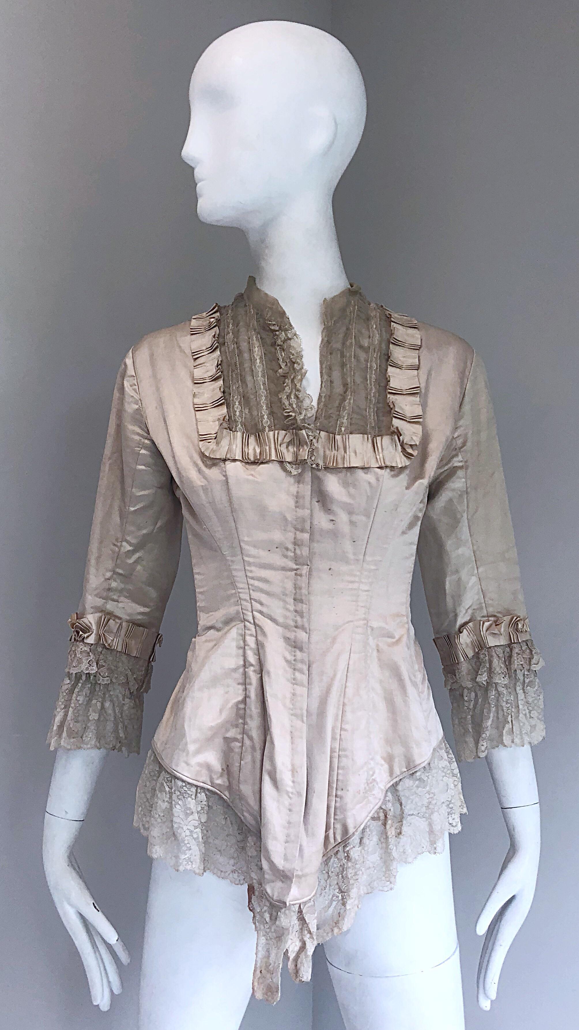 Incredible authentic Victorian Era (approximately 1880s) ivory silk lace corset bustier blouse! Features a fitted boned bodice with 
hook-and-eye closures up the front. Puckered silk details around the neck and sleeve cuffs. Layers of matching