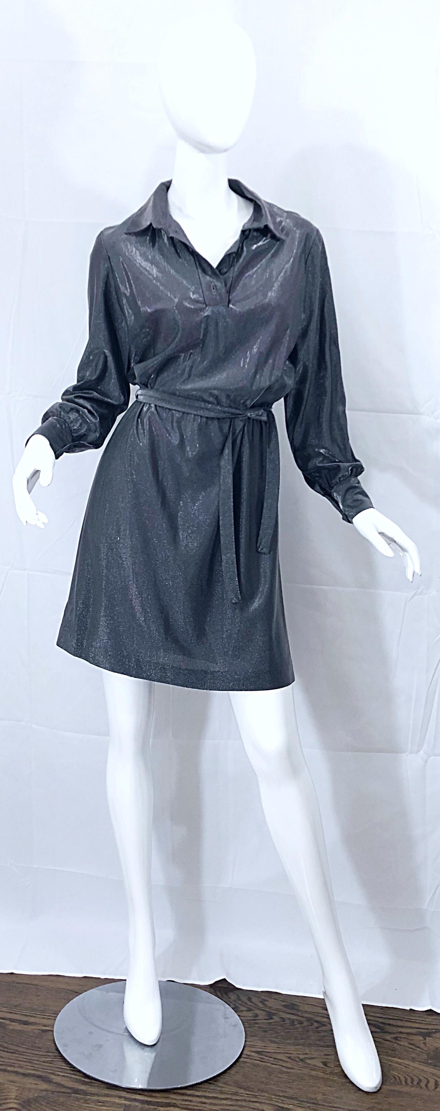 Wonderful 1970s gunmetal metallic long sleeve belted shirt dress! Features a loose fitting bodice that is both comfortable and flattering. Buttons up at neck and at each sleeve cuff. Built in interior elastic waistband stretches to fit an array of