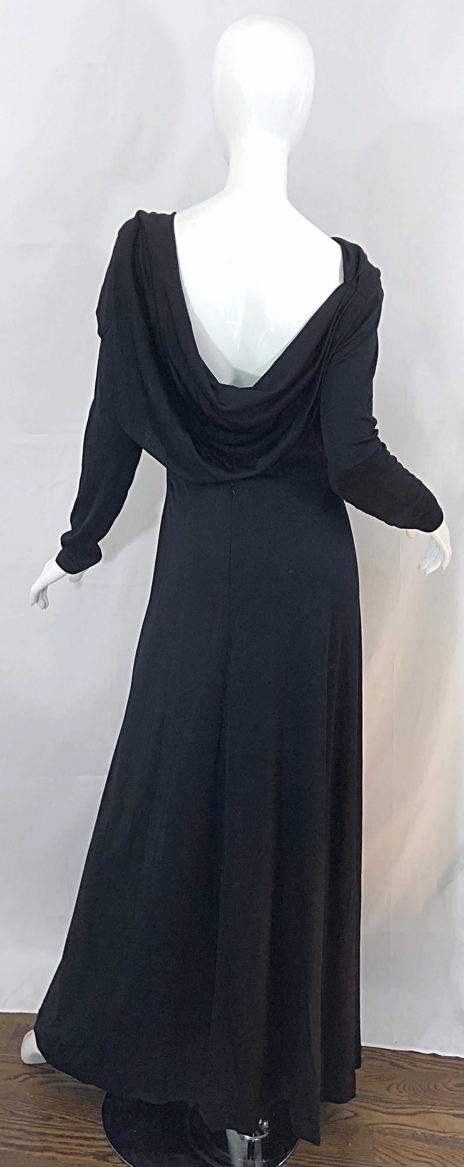 Beautiful 70s ESTEVEZ Couture black long sleeve jersey cape gown! Features a dramatic high neck with a wonderful low-cut draped back that reveals just the right amount of skin. From the side, the dress looks to have a cape. Hidden zipper up the back