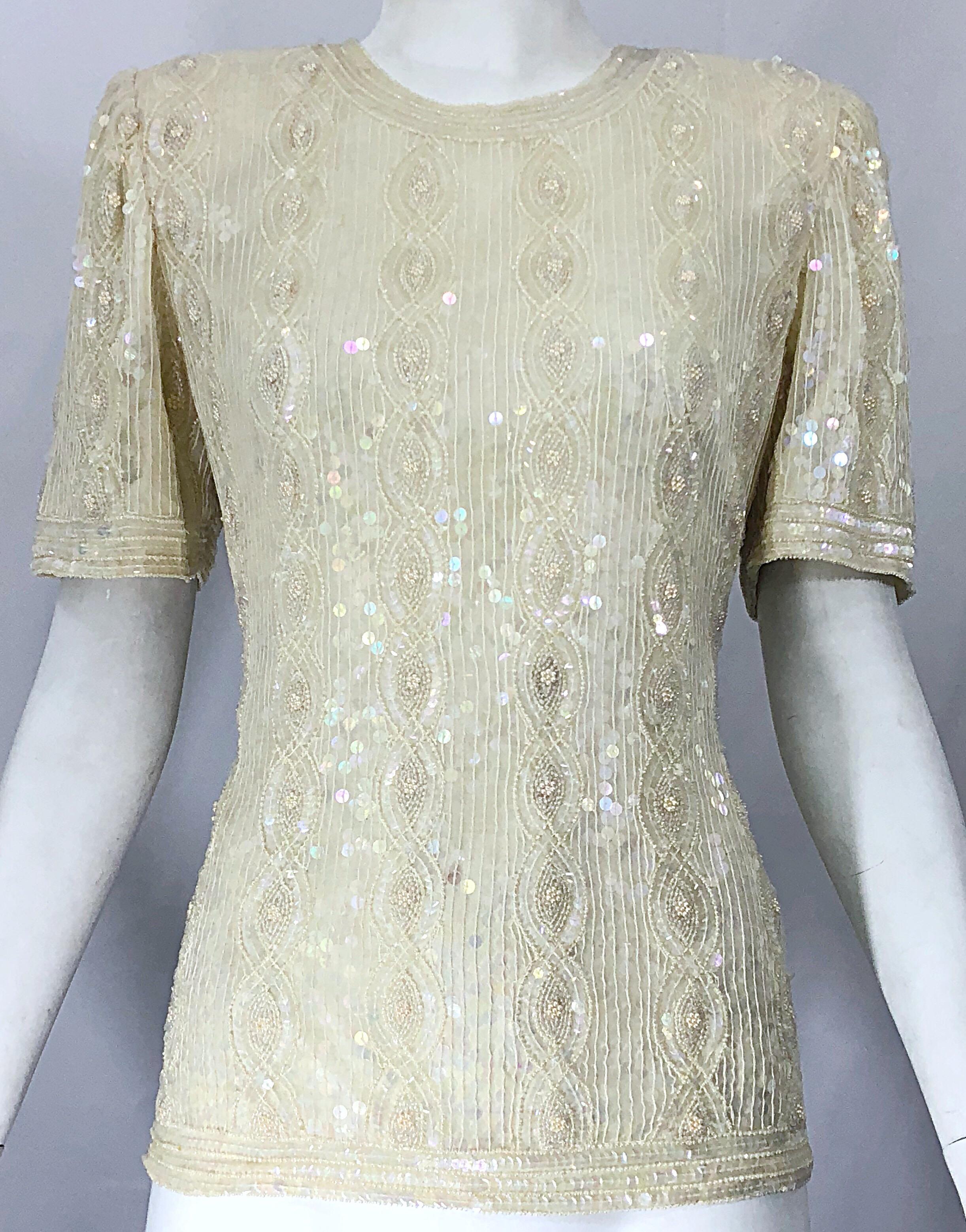 Beautiful vintage ivory / off-white sequined, beaded, and pearl encrusted silk shirt! Features thousands of hand-sewn iridescent sequins throughout. Pearls and beads scattered throughout. Hidden zipper up the back with hook-and-eye closure. Very