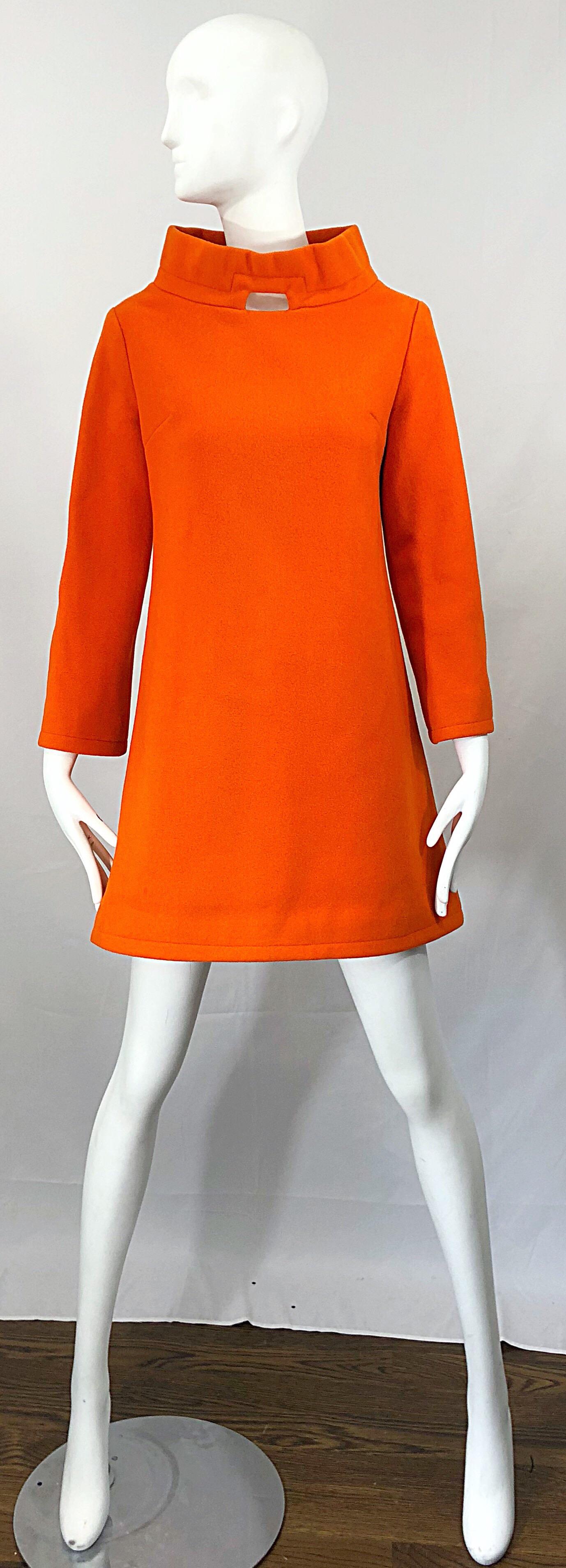 Insanely chic 1960s LIONEL & ELVIA orange wool A-Line mini dress or tunic! Features a stylish funnel neck with a cut-out at center neck. Full metal zipper up the back with hook-and-eye closures at back neck. Fully lined. Tailored bodice with a