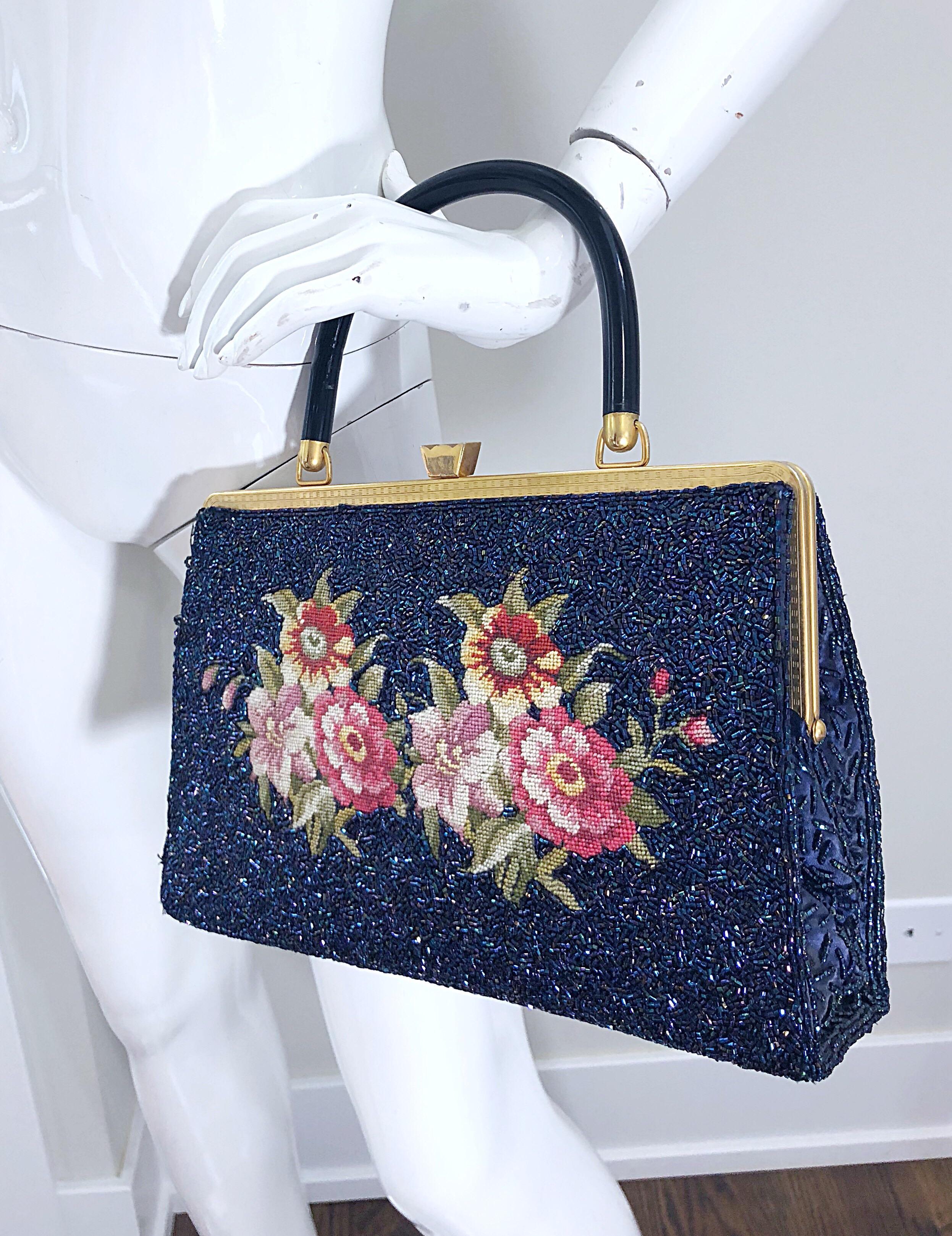 Gorgeous vintage late 1950s large fully beaded British Hong Kong needlepoint tapestry handbag! Features thousands of iridescent navy blue seed beads throughout. Needlepoint flowers on the front. Gold frame locks shut securely. Black lucite handle. I