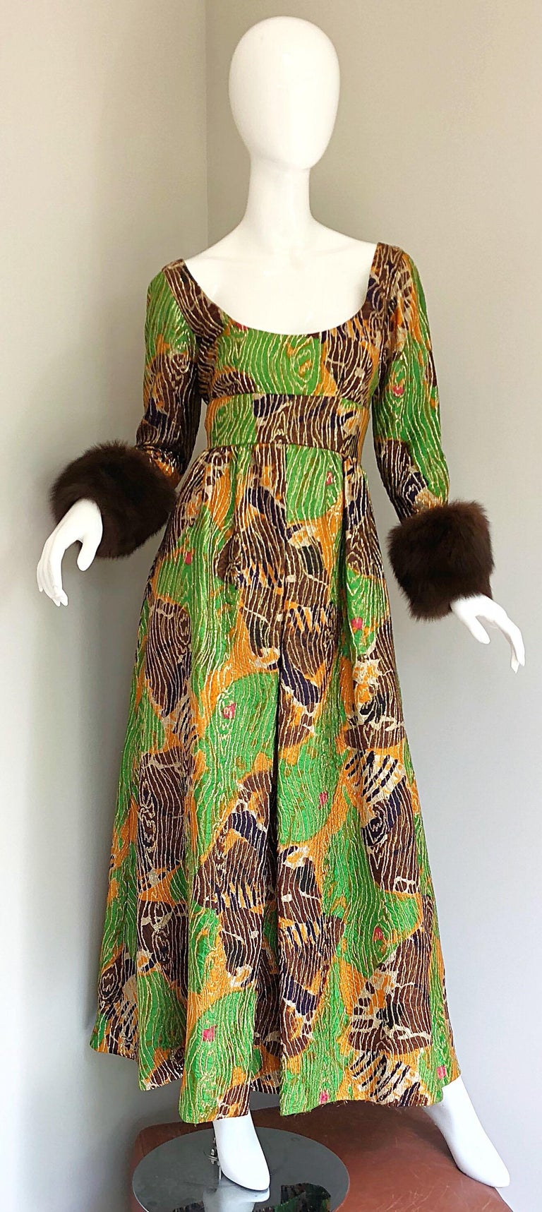 Stunning 1970s vintage LILLIE RUBIN green, purple and orange silk metallic gown! Features soft genuine mink fur sleeve cuffs. Fitted bodice with a full forgiving skirt. Abstract print in vibrant hues of green, purple, and marigold orange, with gold