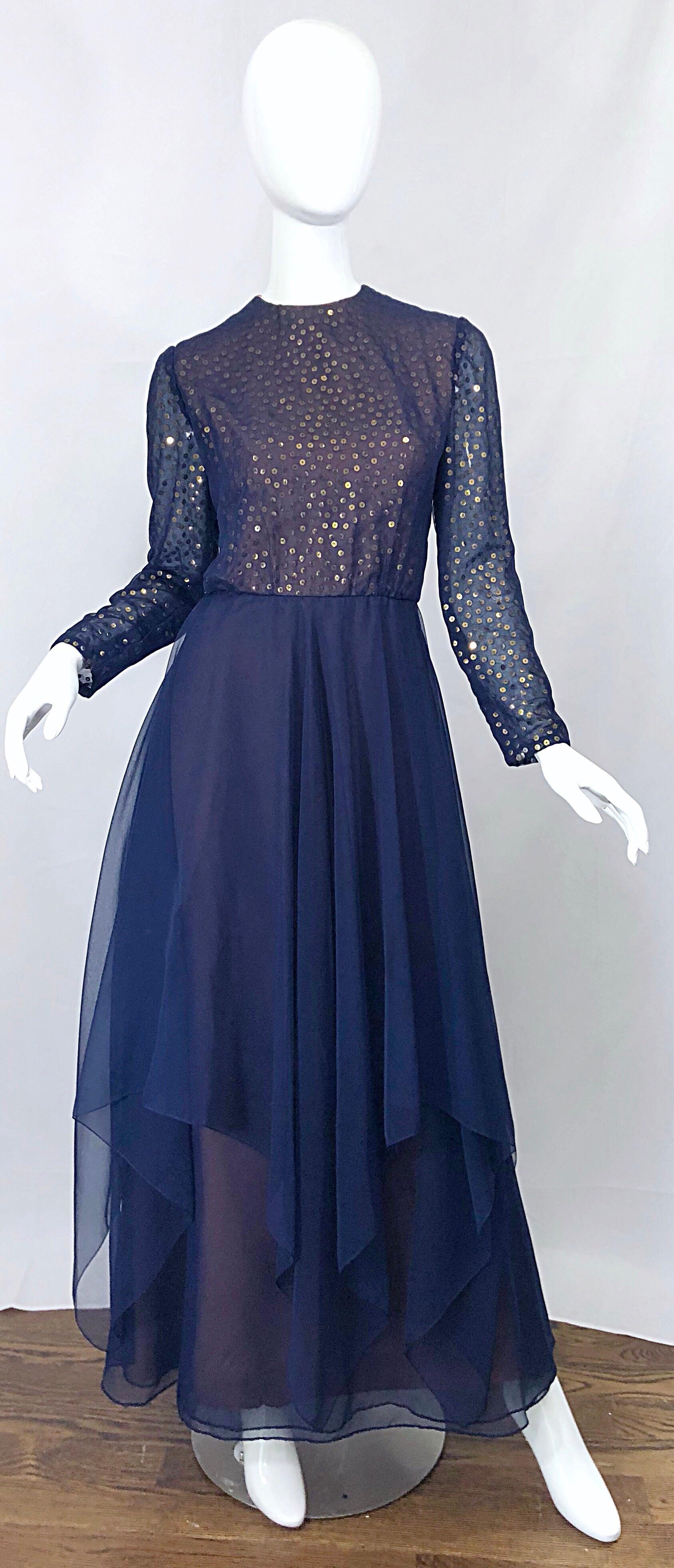 Gorgeous late 1960s KIKI HART navy blue and gold sequined chiffon long sleeve gown! Features a nude taffeta underlay that peaks through the bottom layer of the asymmetrical hem. Hundreds of gold sequins hand-sewn on the underlay of the tailored