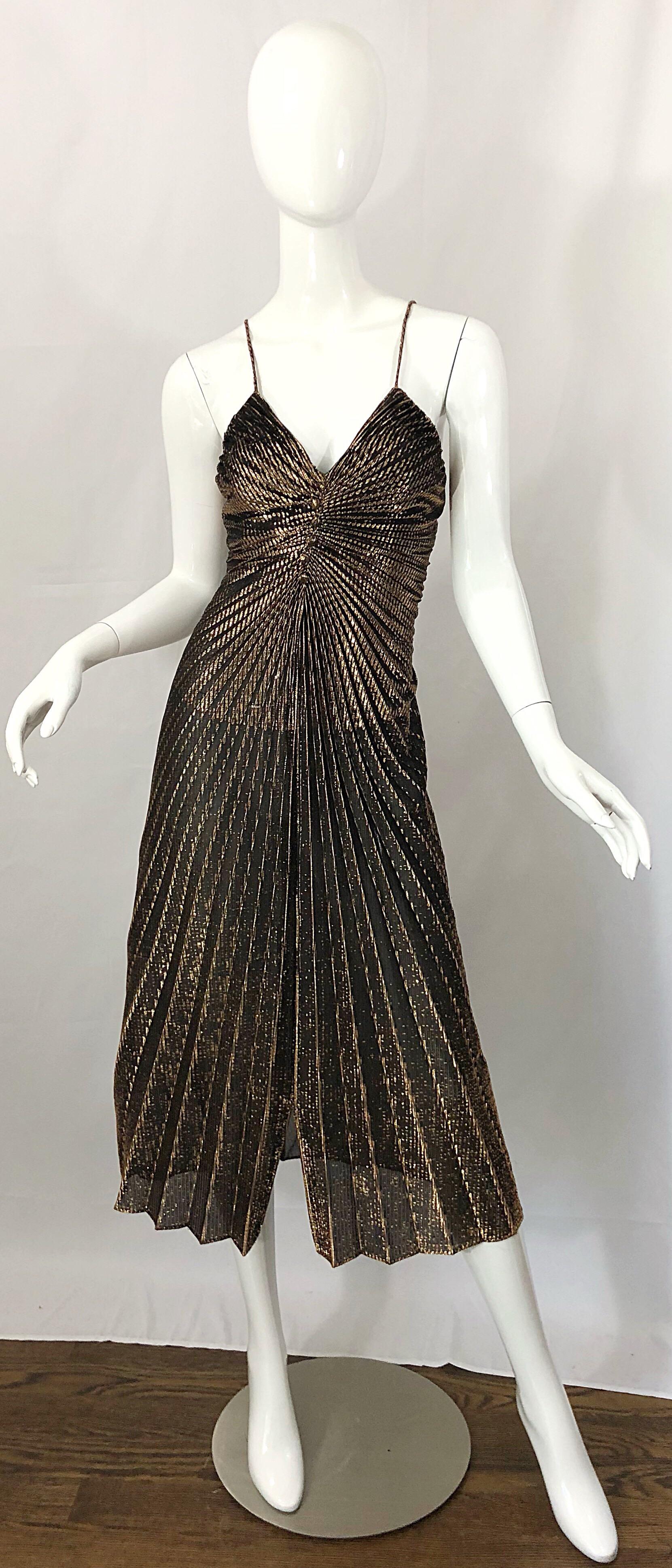 Amazing 1970s slinky gold / bronze pleated Studio 54 disco dress! Features flattering accordian pleating on the front. Mock fabric covered buttons at center bust. Hidden zipper up the back. This dress looks amazing on! Great with boots or heels. 
In