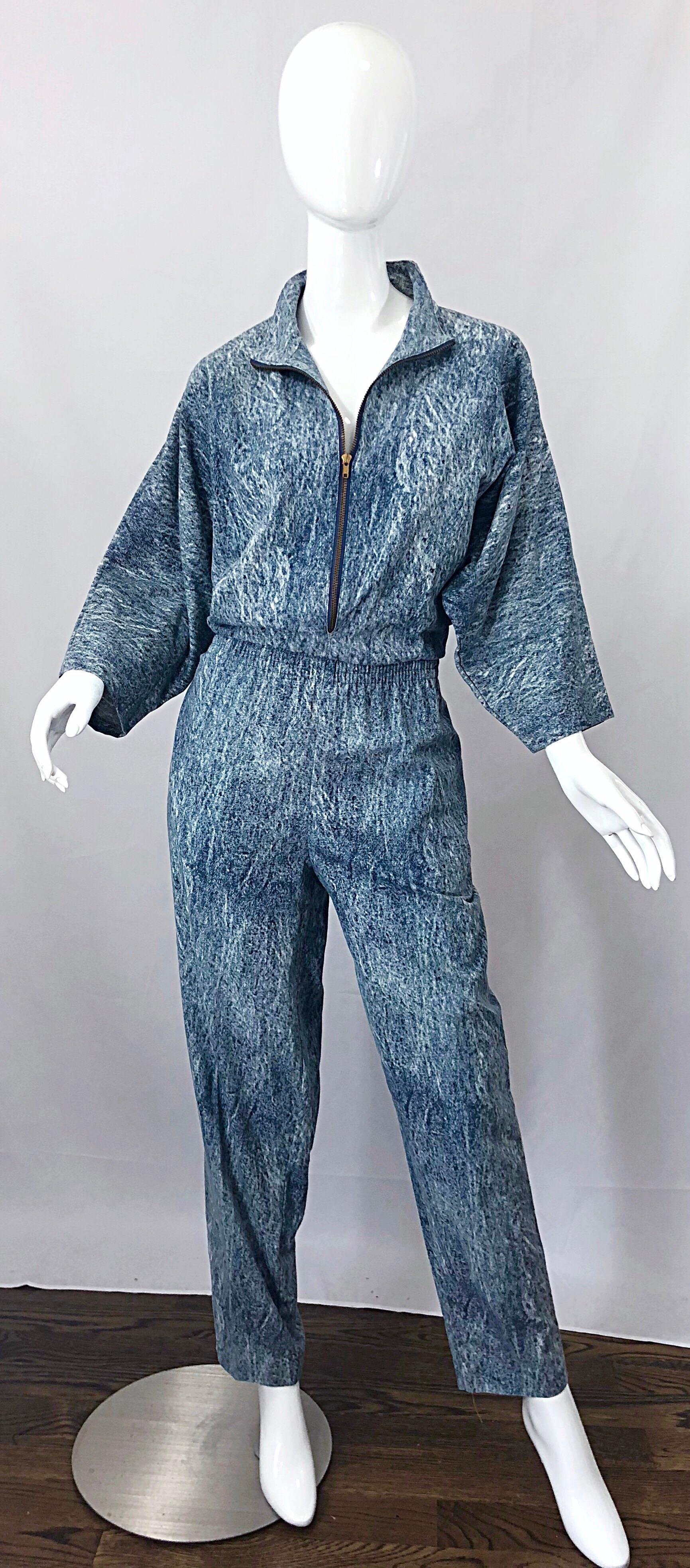Awesome Avant Garde 1980s stone acid wash blue denim dolman sleeve one piece jumpsuit! Features a lightweight fabric that is made to look like denim. Zipper up the front allows cleavage control--Can be worn open or zipped up. Slouchy bodice with