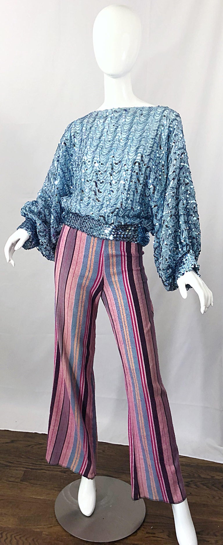 Fabulous vintage 1970s high waisted striped flared leg bell bottom trousers! Features various shades of pinks, blue, and purple throughout. Full metal zipper up the side. Pockets at each side of the rear. The pictured 70s blue sequin top looks great