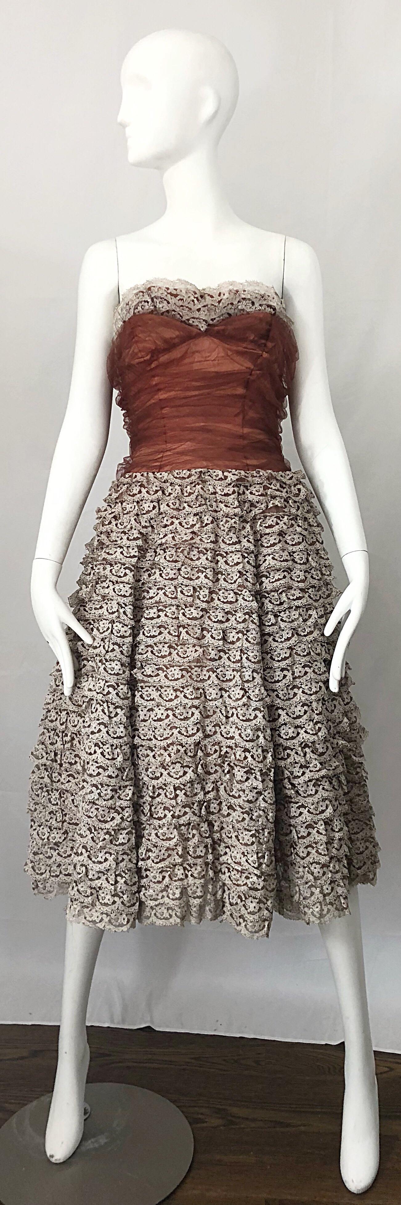 Stunning 1950s demi couture strapless lace dress in terra cotta and taupe. Features a fitted sweetheart bodice with flattering ruched terra cotta mesh tulle. Full flared skirt has rows of taupe lace panels. Full metal zipper up the side with