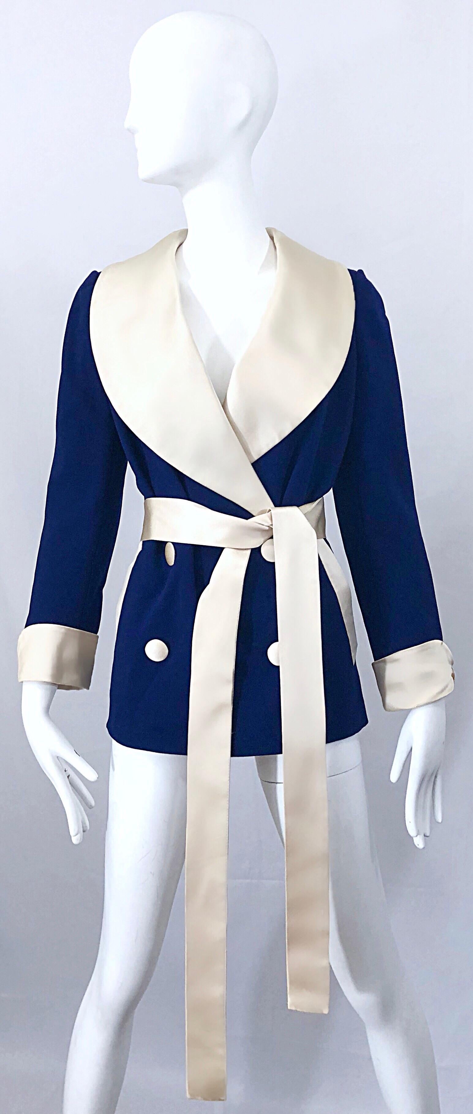 Rare historical piece of fashion from the brilliant NORMAN NORELL! Navy blue wool body, with any ivory satin shawl collar, sleeve cuffs, buttons, pockets and sash belt. Buttons are not functional, as there are hidden snaps behind the buttons. Double