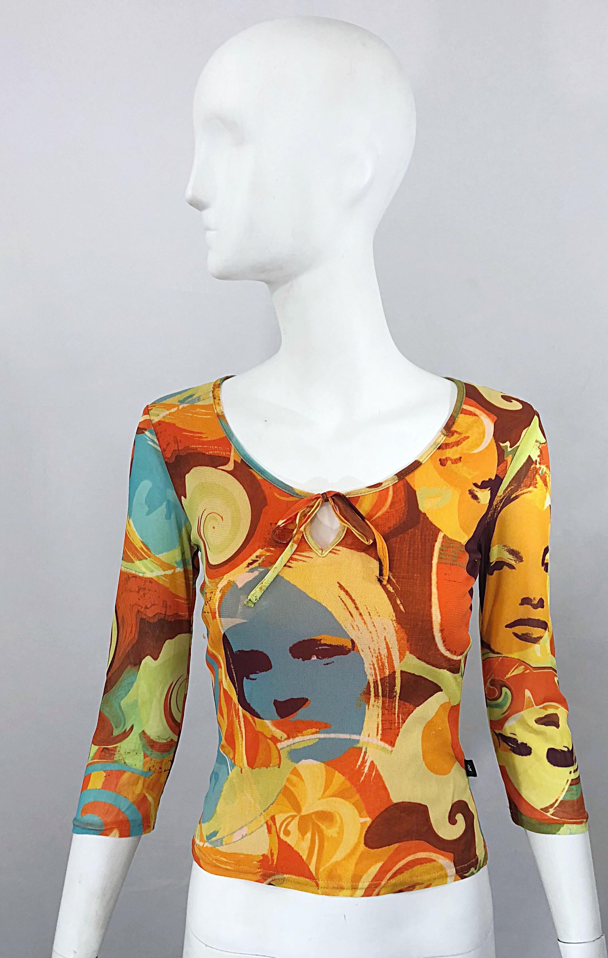 Amazing 90s does 70s French made novelty print 'Covergirl' themed 3/4 sleeves mesh top! Features vibrant warm tones in yellow, orange, blue, green and brown throughout, with impressive bold prints. Ties at center neck can be worn in a bow or hung