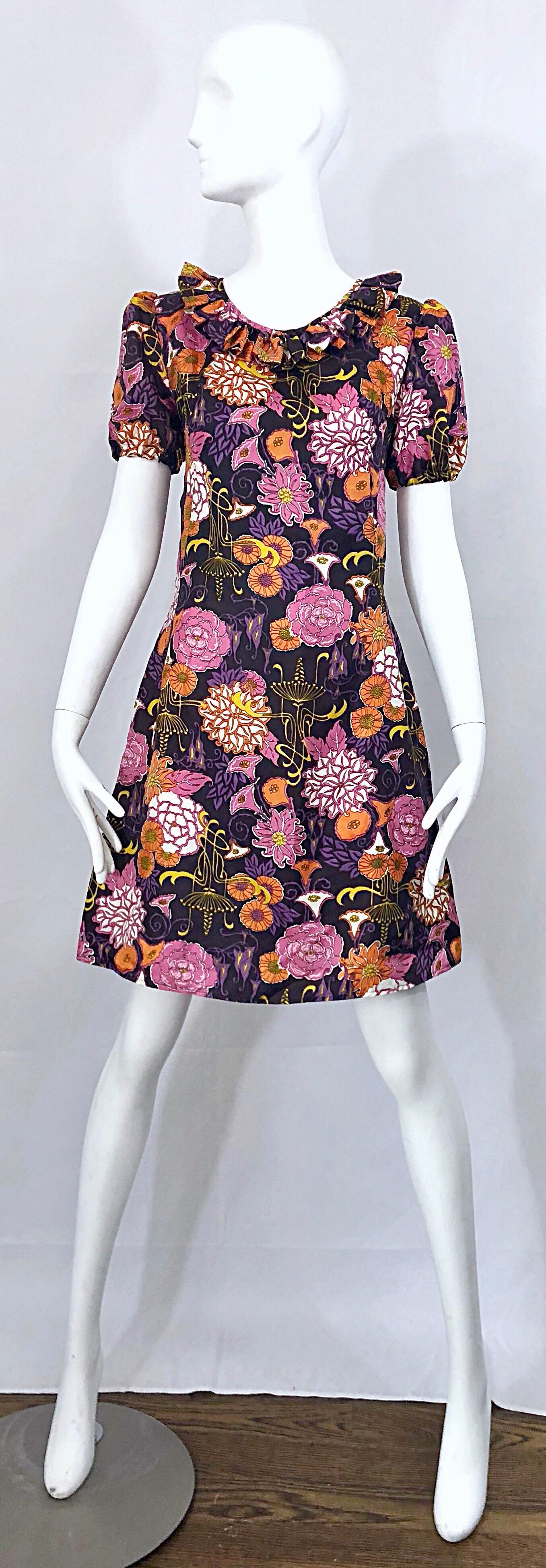 Chic späten 1960er Jahren Lotus Orchidee Neuheit Blumendruck kurze Puffärmel Vintage A-Linie Kleid! Der dunkelviolette Hintergrund ist mit rosafarbenen, orangefarbenen, gelben und lavendelfarbenen Lotosblumen, Orchideen und Blumen bedruckt. Der