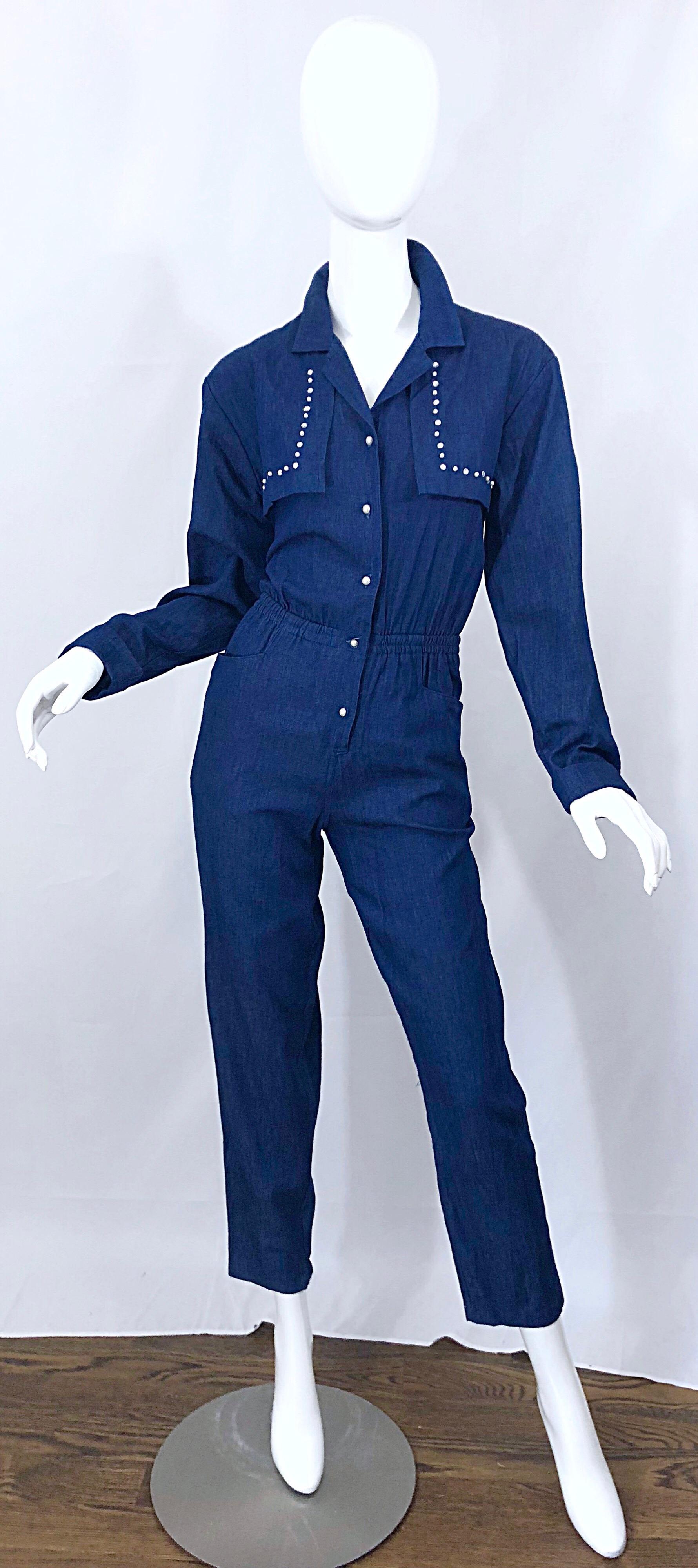 Amazing 90s French Designer (Miss Jett) dark blue denim jean one piece jumpsuit! Encrusted with rhinestones and pearls hand-sewn on the chest lapels, with pearl buttons up the front. Smart tailored bodice with a forgiving elastic waistband. POCKETS