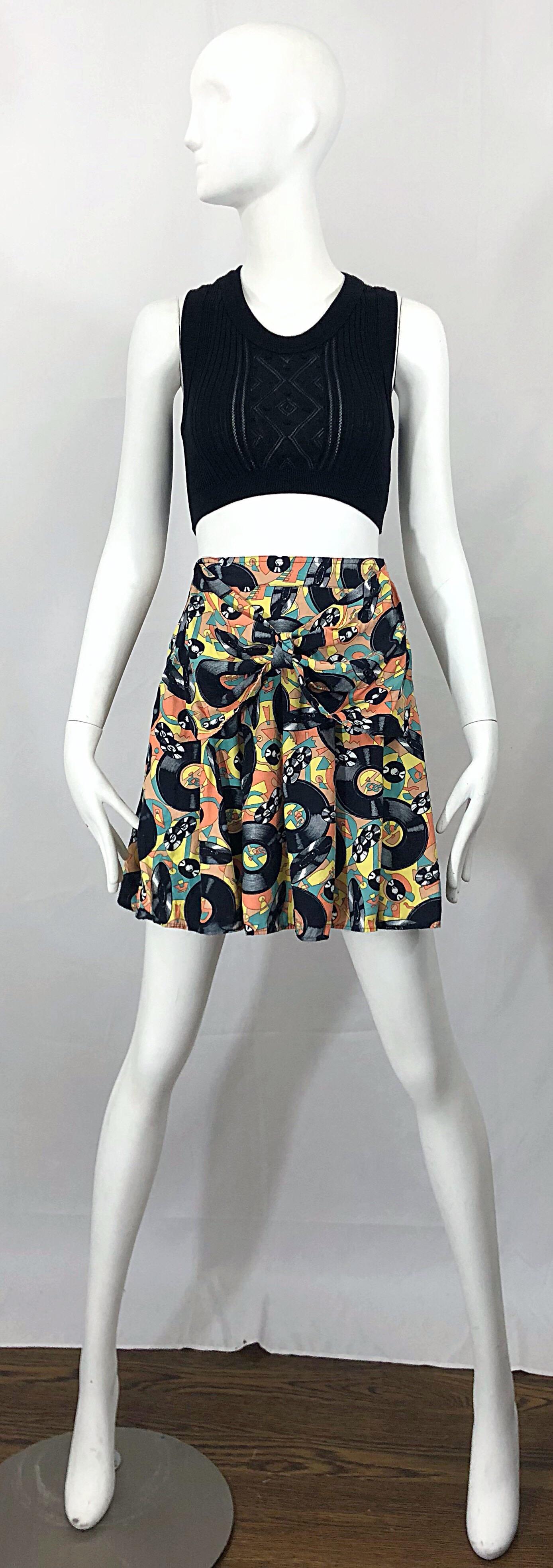 Awesome early 90s record novelty print music themed mini skirt! Features records, with a 50s diner background. Unique bow detail at front waist. Soft fabric feels like a rayon cotton blend. Hidden zipper up the side. The vintage Jean Paul Gaultier