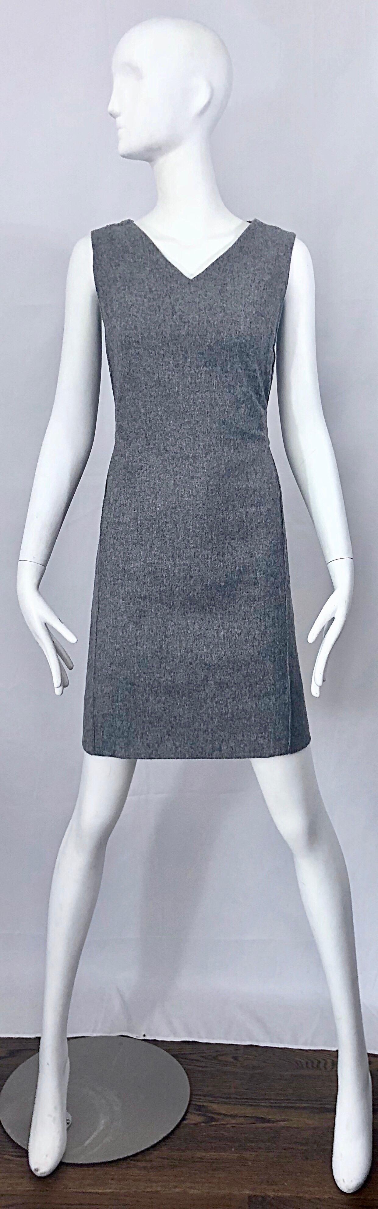 Chic 1960s light heather grey sleeveless wool shift dress! Features a tailored silhouette, with a belted back. Full metal zipper. Up the back with hook-and-eye closure. Great with boots, flats or heels. Fully lined, and very well made. 
In great