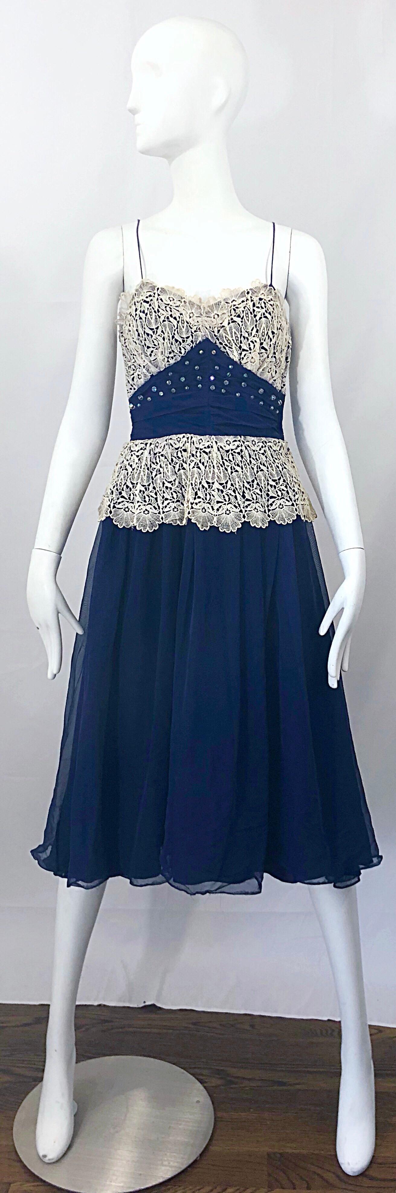 Beautiful 1950s FRED PERLBERG navy blue and ivory lace rhinestone sleeveless dress! Features a pretty navy blue fabric with ivory lace at bust and waist. Sparkly rhinestone sequins adorn the front bodice. Tailored fitted bodice with a forgiving full