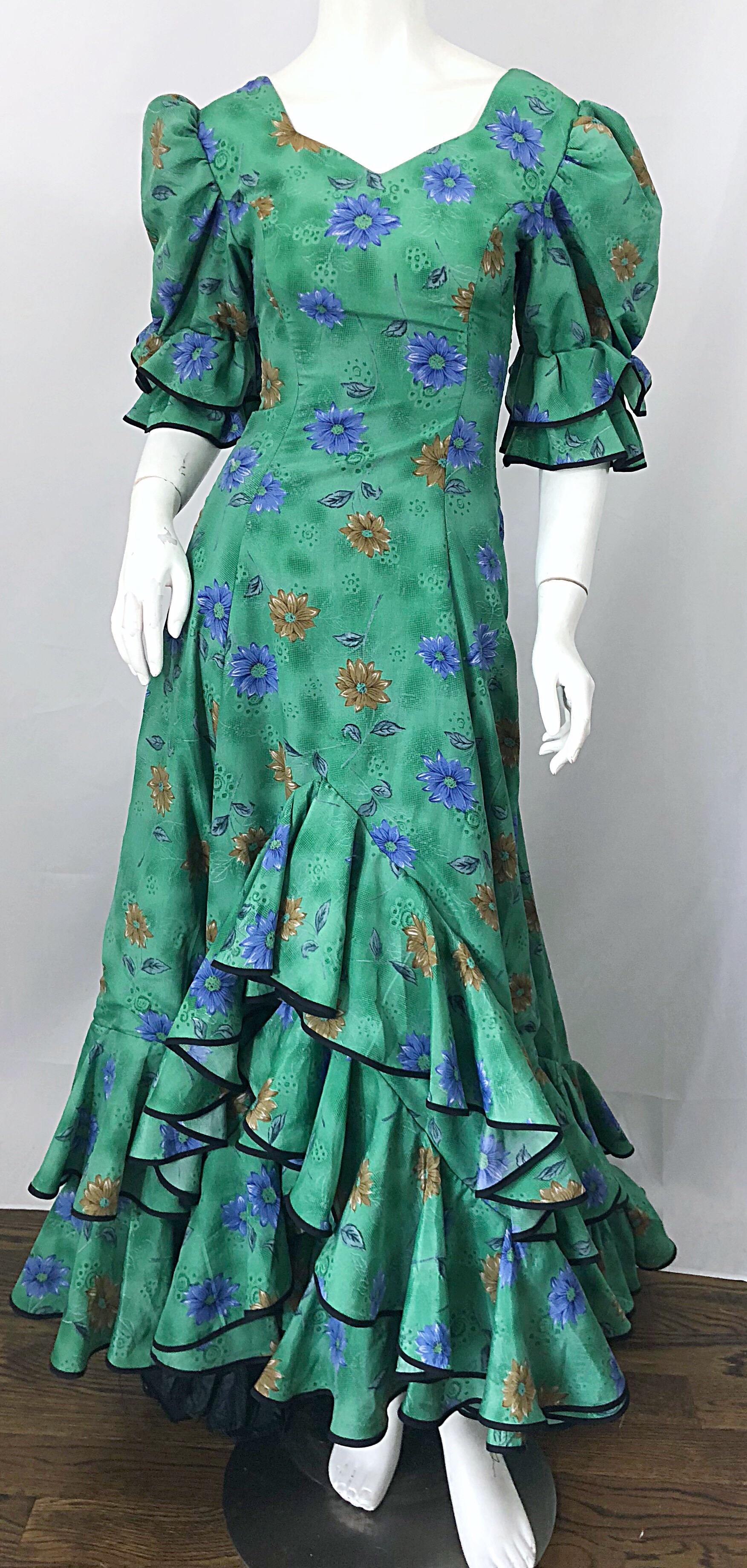 Amazing vintage Victorian inspired 70s does 1800s green steampunk trained dress! Features a beautiful color of green with blue and brown flowers throughout. Chic puff sleeves and a dramatic long ruffle train hem. Ruffles at hem and at each sleeve