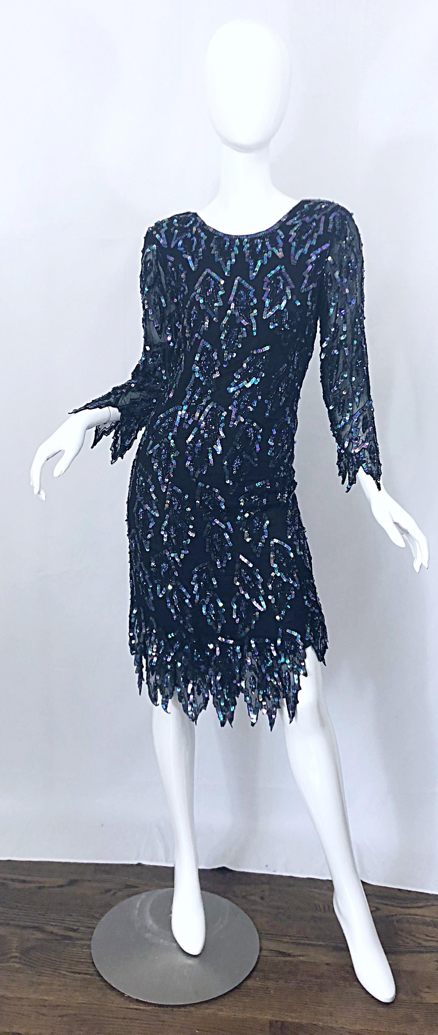 Stunning early 1990s black silk chiffon carwash hem sequined flapper inspired dress! Features luxurious silk chiffon layers with thousands of hand-sewn iridescent metallic sequins. Asymmetrical car wash hem looks fabulous with movement, and are also