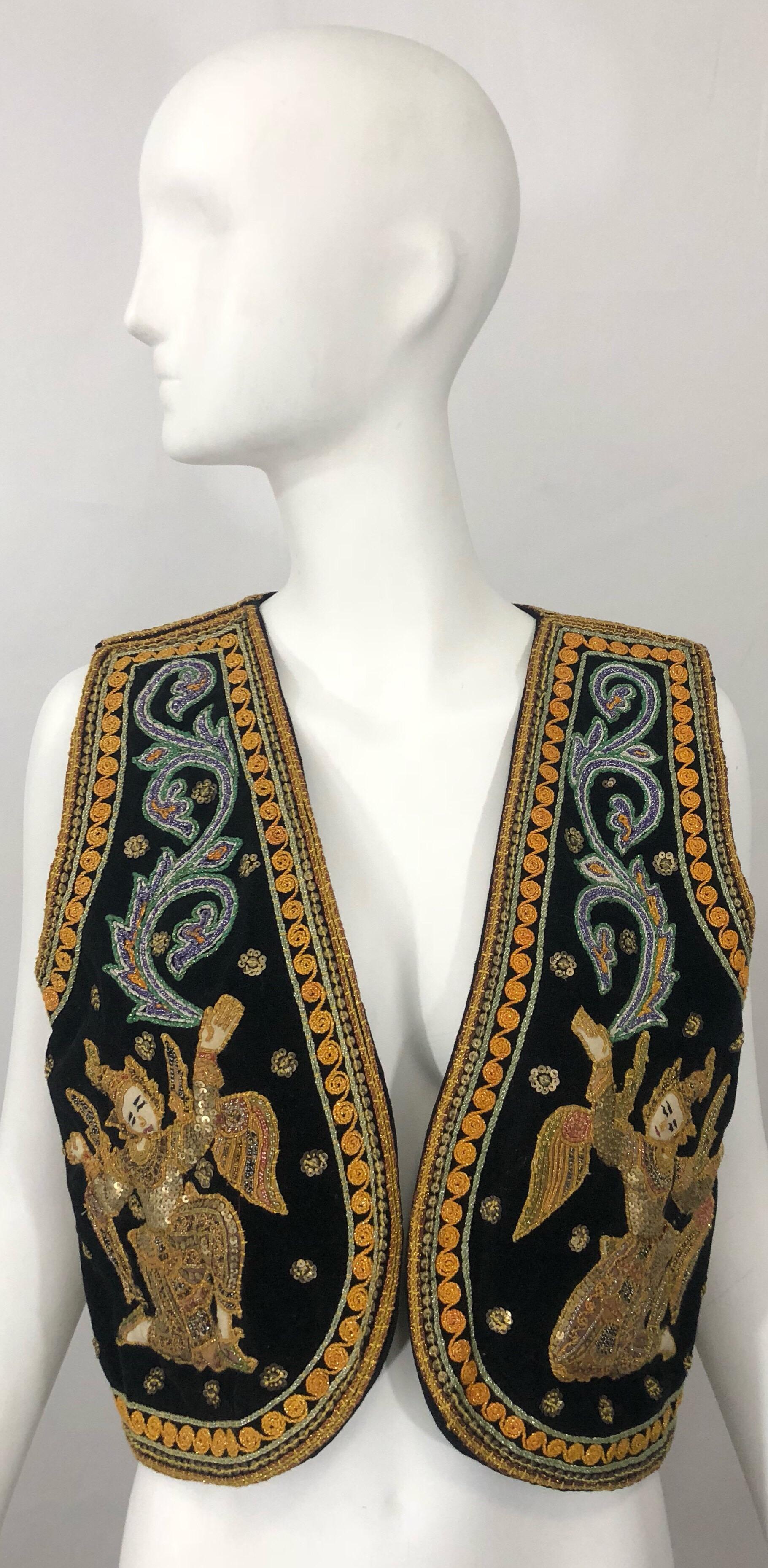 Amazing 1970s Egyptian inspired 3-D embroidered black velvet boho sequined crop vest!  Features intricate embroidery on the front and back. Vibrant colors of yellow, blue, red, red and gold throughout. Hundreds of small hand-sewn sequins throughout