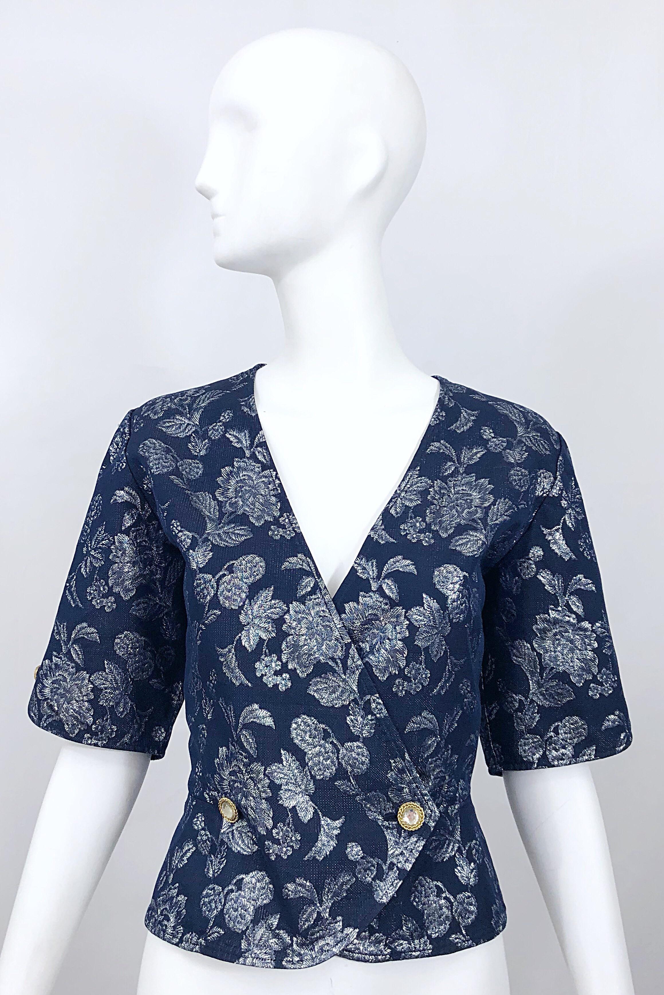 Beautiful vintage 1990s EMANUEL UNGARO navy blue and silver gunmetal double breasted blouse jacket! Features a rich deep blue hue with muted silver metallic floral print throughout. Double breasted style with rhinestone buttons. Rhinestone button