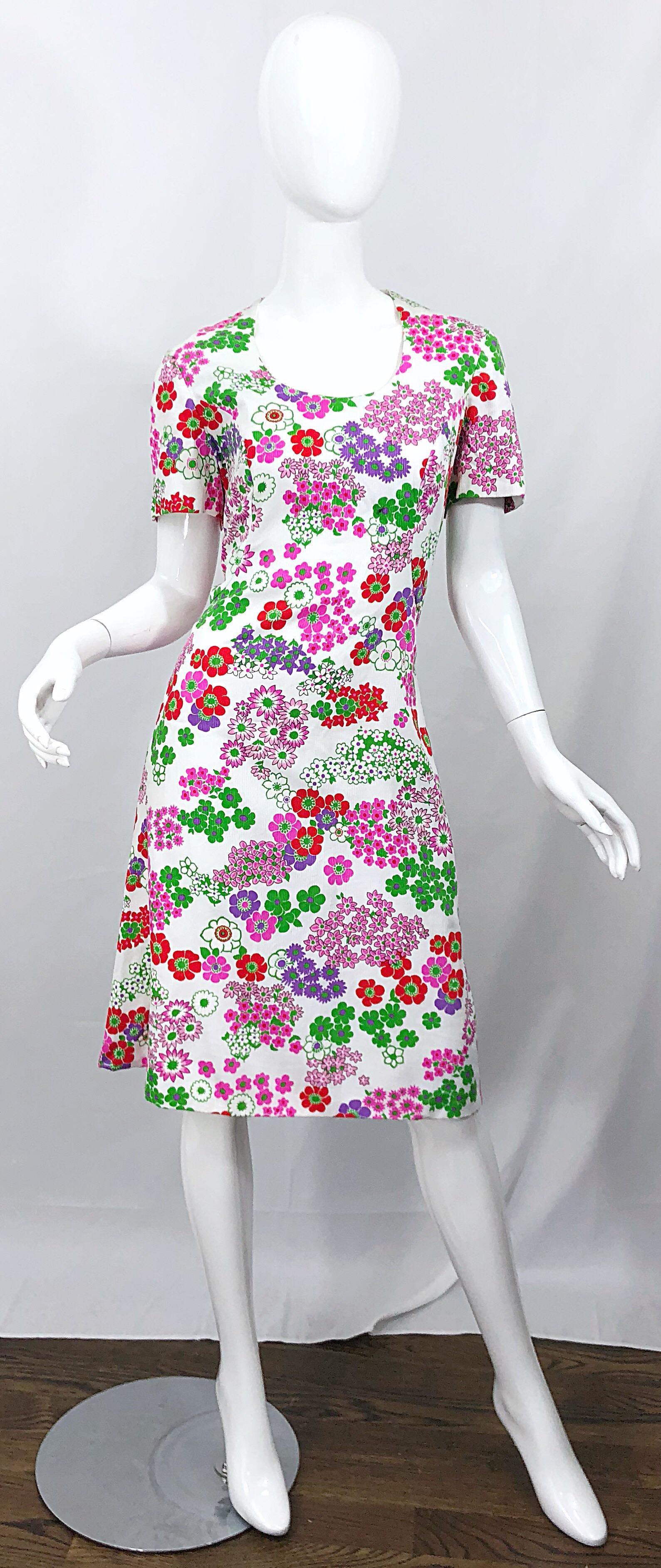 Chic 1960s SAKS 5TH AVENUE silk and cotton short sleeve 
A-Line dress! Features a stark white background with flowers in vibrant colors of purple, pink, red, and green throughout. Fully lined. Full metal zipper up the back with hook-and-eye closure.