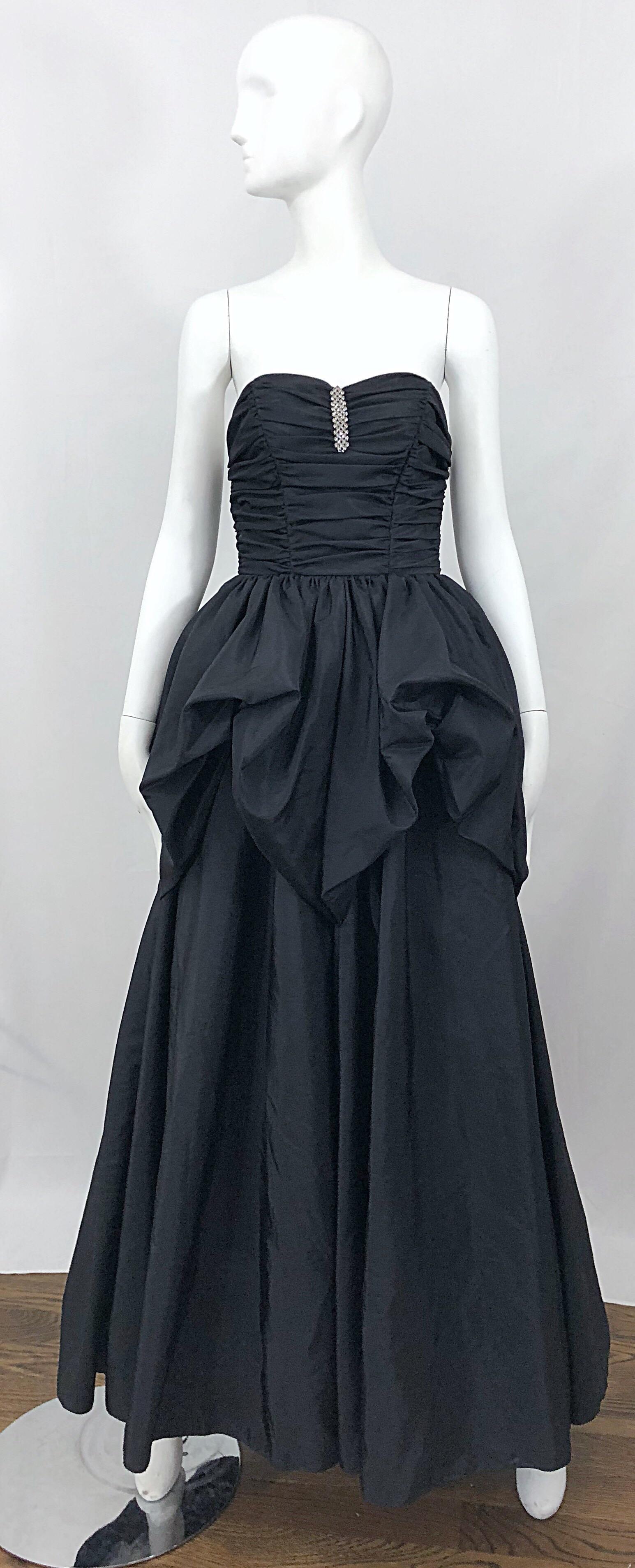 Fabulous vintage 80s MIKE BENET black taffeta strapless bustle gown! Features a ruched boned bodice with sparkly rhinestones at center. Bustle style pouf skirt leads to an elegant long skirt. Hidden zipper up the back with hook-and-eye closure. Has