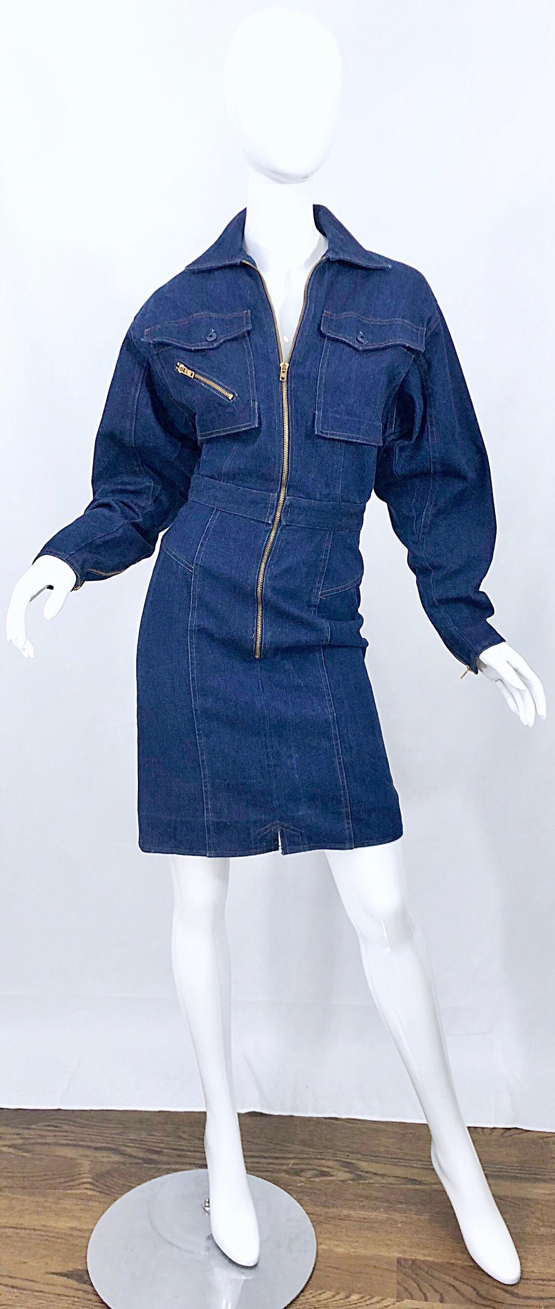Superbe robe moto en jean bleu Avant Garde du milieu des années 1980 ! Il est doté d'une fermeture à glissière en métal doré sur le devant, d'une fermeture à glissière asymétrique sur la poche de poitrine droite et sur l'arrière. Fermeture par