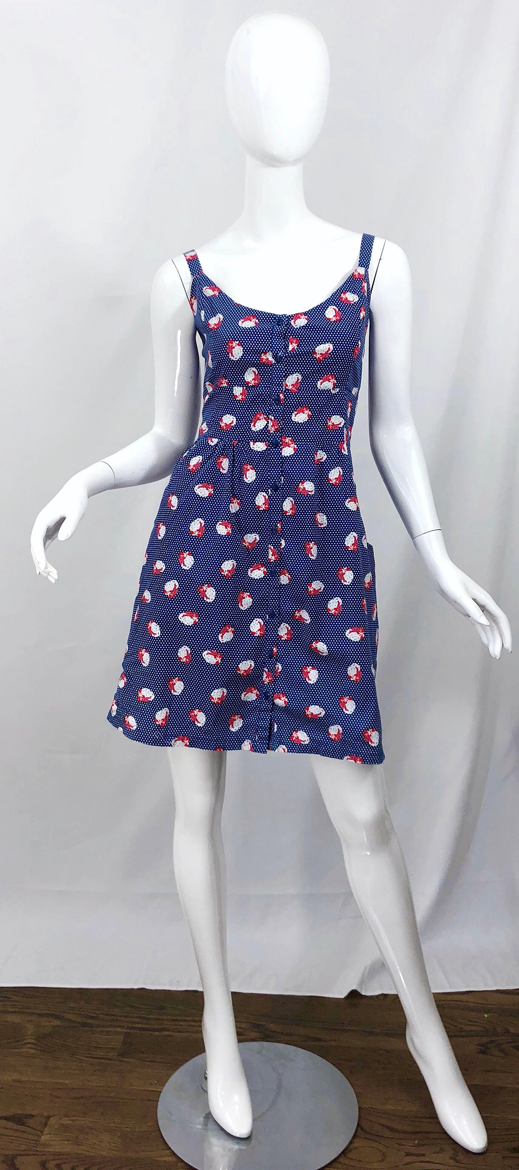 The cutest 1970s novelty print jumper dress! This cotton number features a rich blue with red and white strawberries and mini polka dots throughout. Adjustable sleeve straps can be made longer or shorter. Buttons up the front. POCKETS at each side