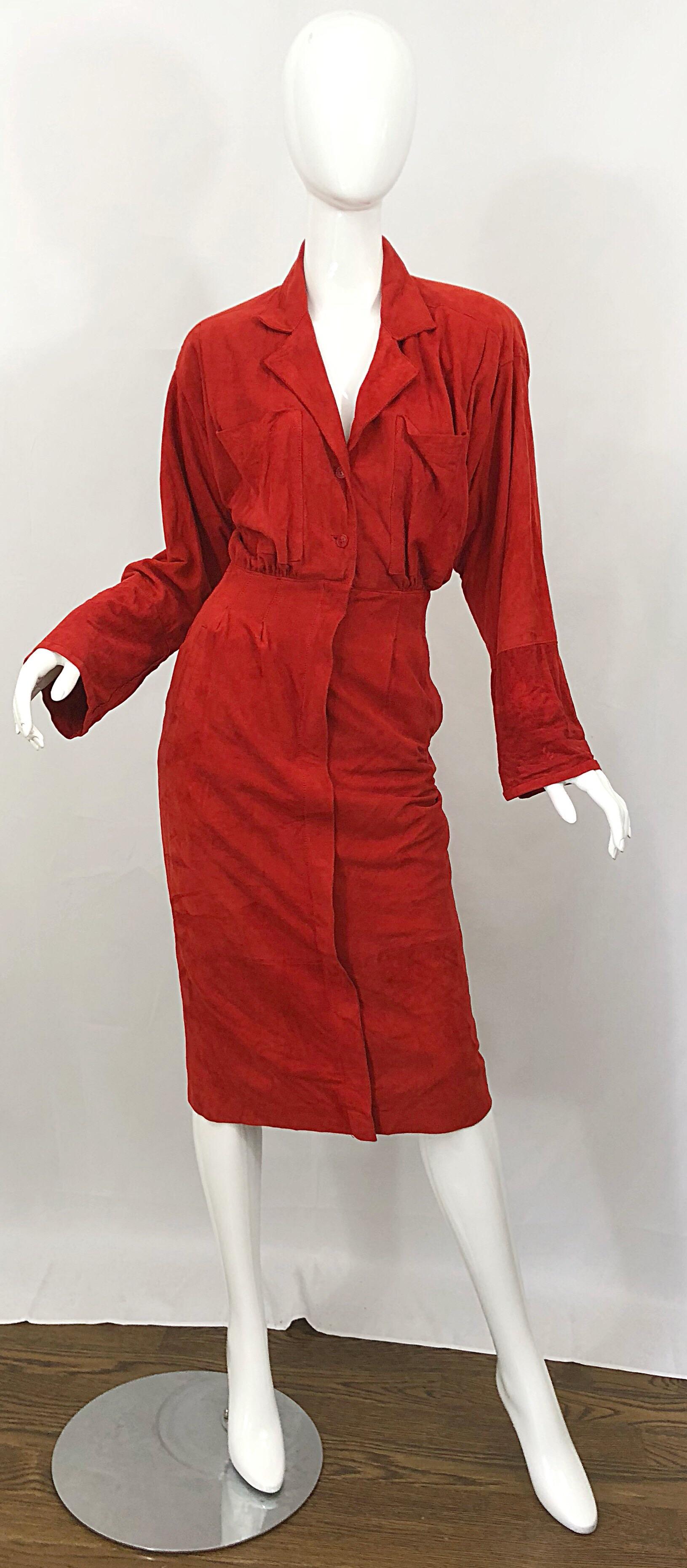 Chic rust red suede leather shirt jacket dress! Features a beautiful warm tone of red that really looks great on pretty much any skin tone. Loose fitting bodice with pockets at each breast. Sleeves feature a slight flare. Hidden buttons up the
