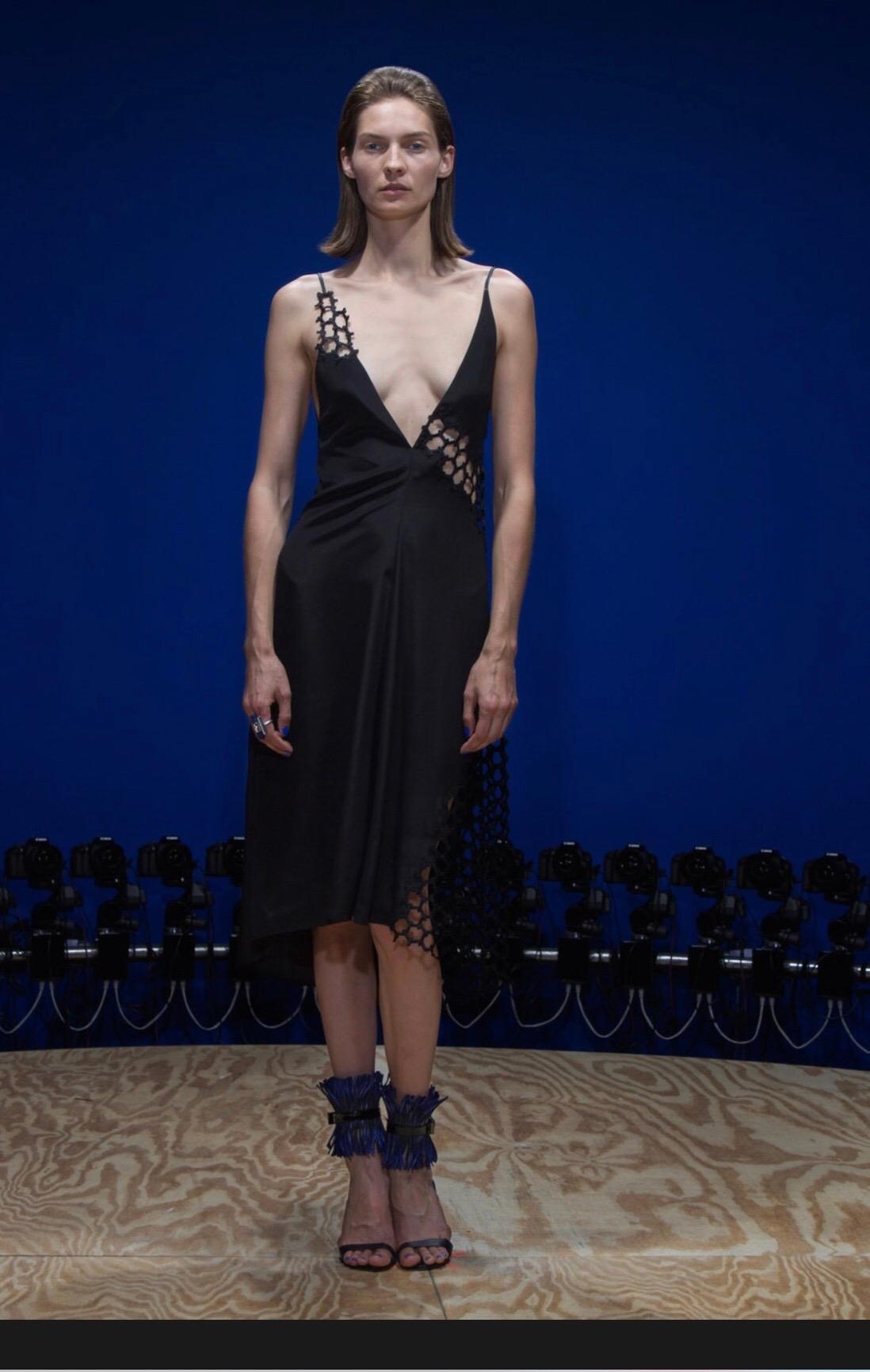 Chic REED KRAKOFF Runway Spring 2015 black and nude cut-out honeycomb dip hem halter minimalist dress! Features honeycomb cut-out details at side bust that is lined in nude silk. Matching honeycomb cut-outs at left hem reveal bare leg. Drapes the
