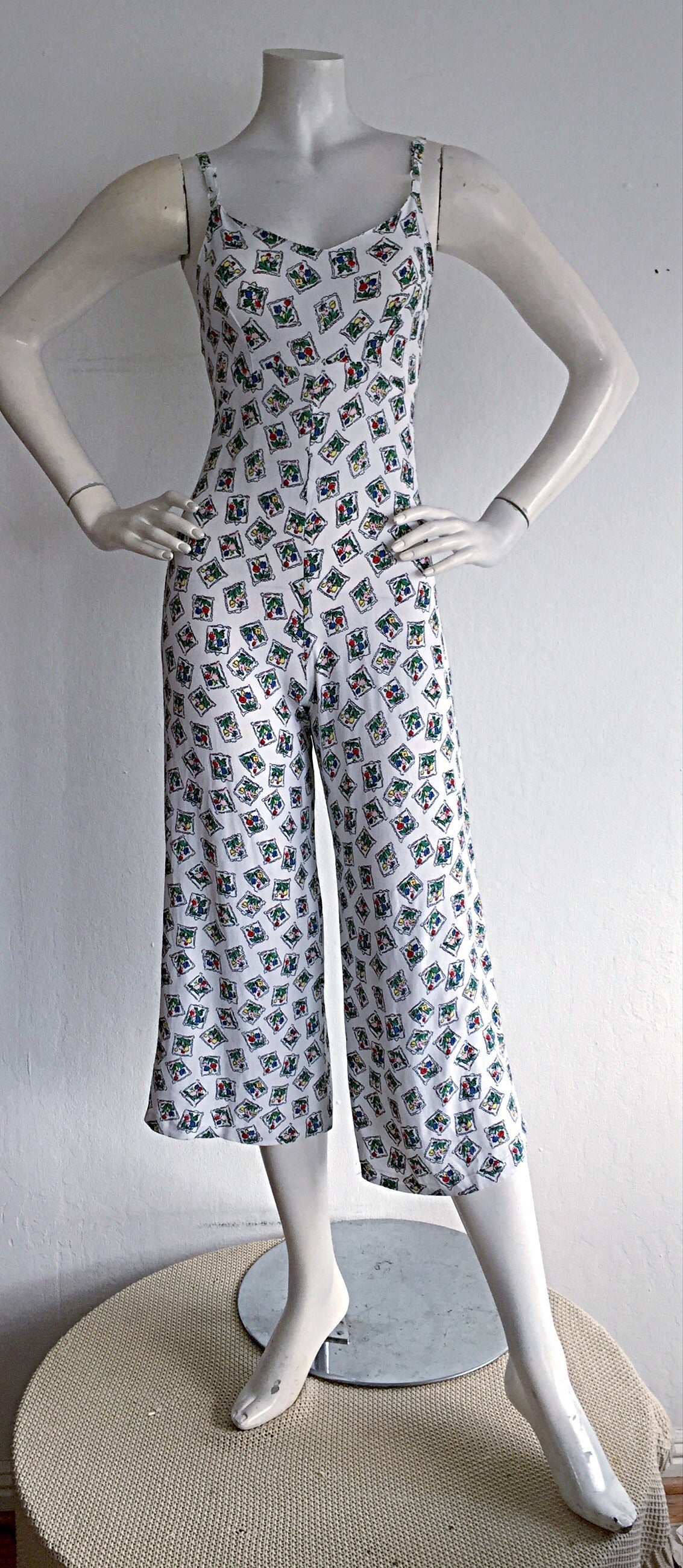 Adorable vintage 1990s Betsey Johnson white silk culottes Jumpsuit/Playsuit! Wonderful floral print throughout. Adjustable strap length, with hidden zipper up the back. Ultra flattering fit, with a flared leg. Can easily be dressed up or down. Looks