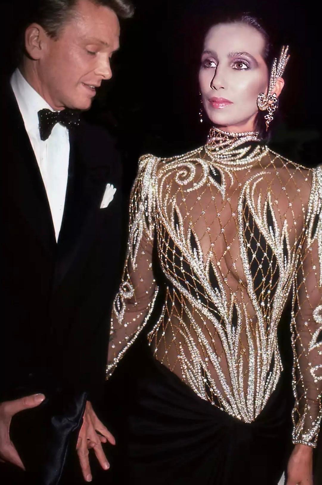 Sexy abito da sera anni '80 di Bob Mackie in chiffon di seta con perline e paillettes! Corpetto trasparente con migliaia di paillettes e perline d'oro e d'argento cucite a mano e posizionate strategicamente per coprire il busto. Taglia la gamba