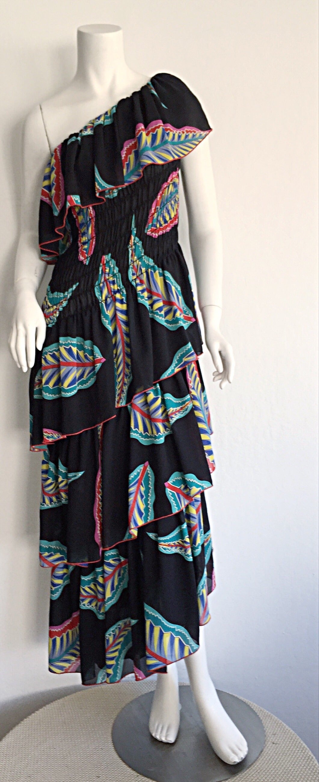 Beautiful 70s Lillie Rubin one shoulder Bohemian dress! Colorful feather print throughout, with layers of tiers that flatter the figure! Optional spaghetti strap that easily tucks in for sporting one-shoulder. Asymmetrical hem. This beauty easily